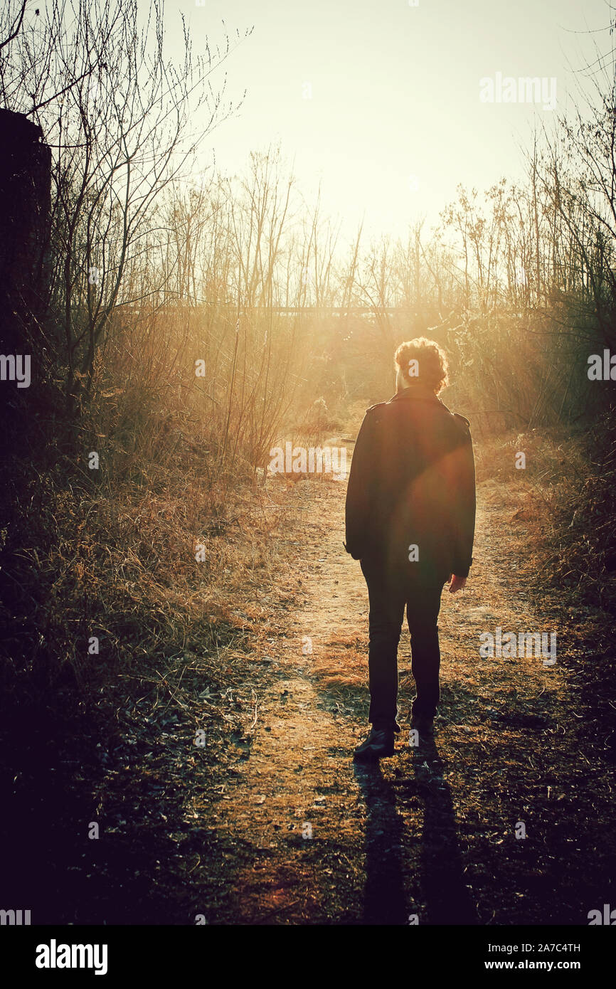 Lonely Man Walking At Sunset In A Forest Mysterious Person Walks In Abandoned Places Stock Photo Alamy