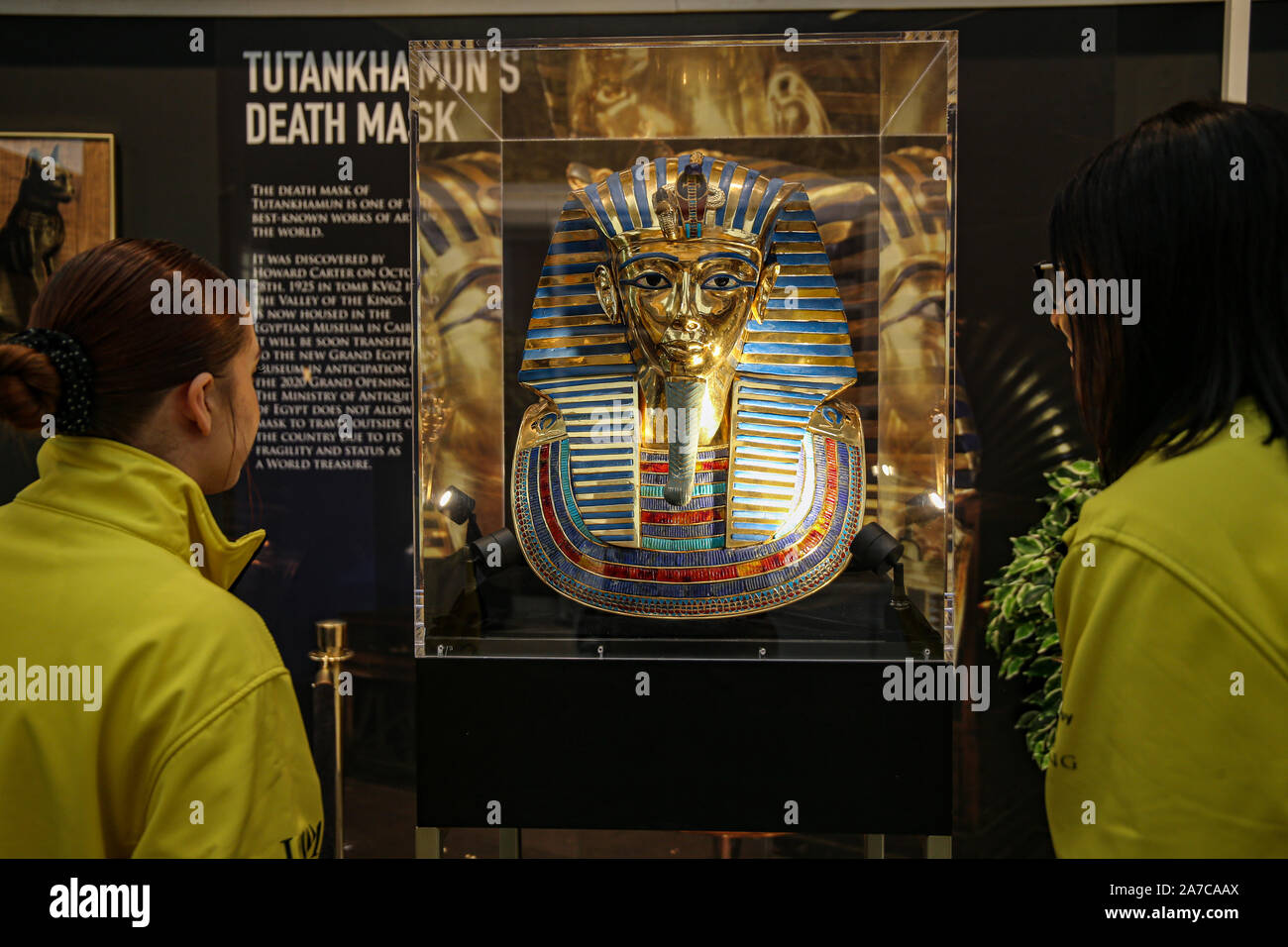 London UK 01 November 2019  Two gallery technician at the exhibition looking at Tutankhamuns Death Mask.Howard Carter ,Archaeologist, back in 1922 discovered the tomb of King Tutankhamun, people become obsessed with the history of the boy King and all the artefacts found in the Tomb. Credit: Paul Quezada-Neiman/Alamy Live News Stock Photo