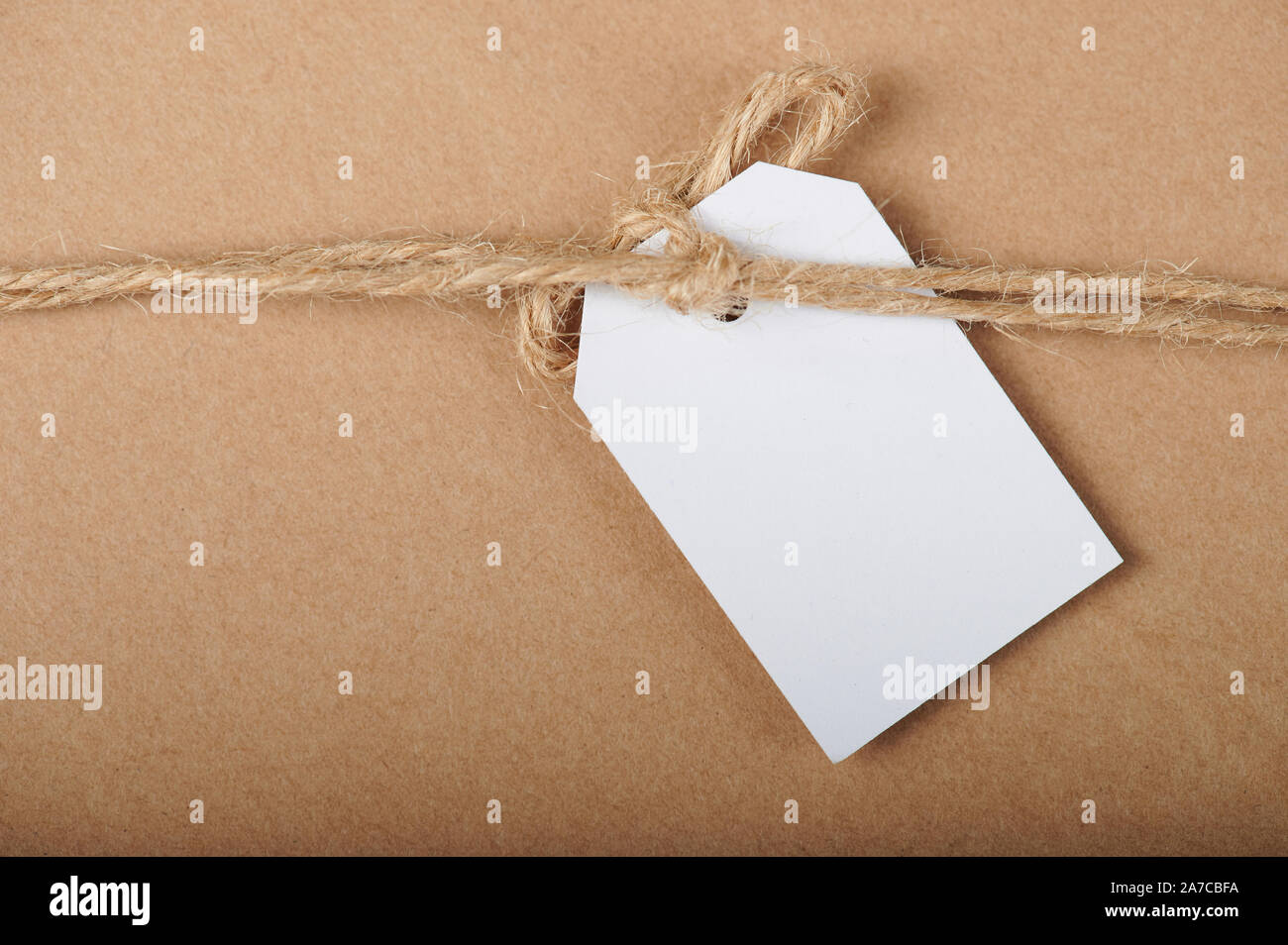 One white paper message tag  on brown carton background Stock Photo