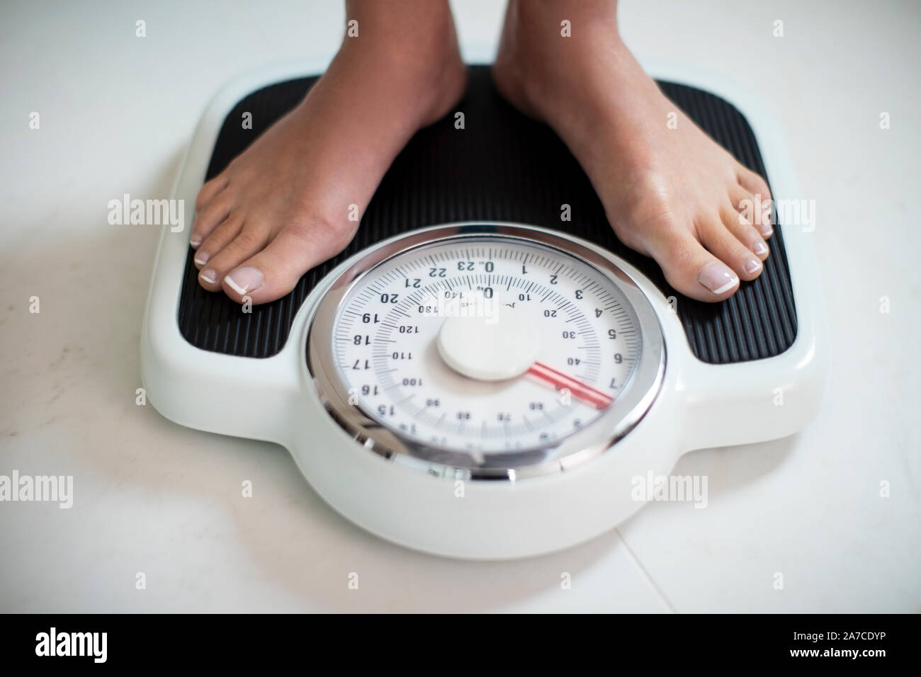Close Up Of Woman Standing On Bathroom Scales At Home Stock Photo