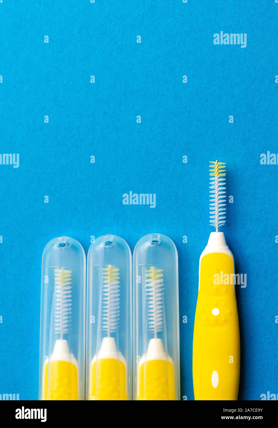 Interdental brush for interdental spaces over blue background. The concept of good mouth hygiene. Stock Photo