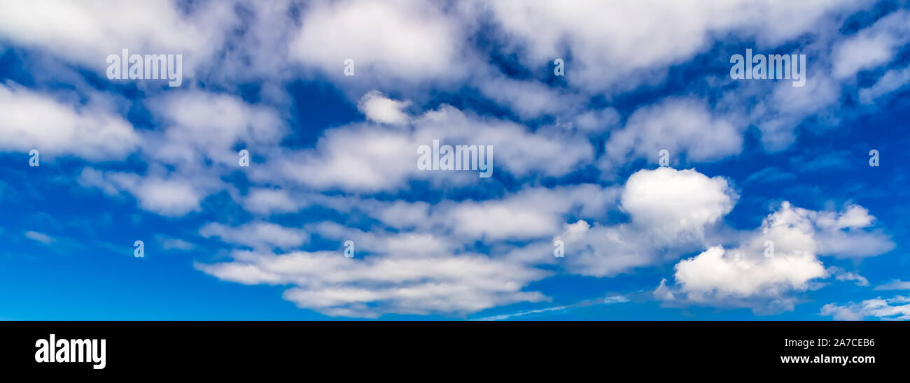 Blue sky background with fluffy white clouds Stock Photo - Alamy