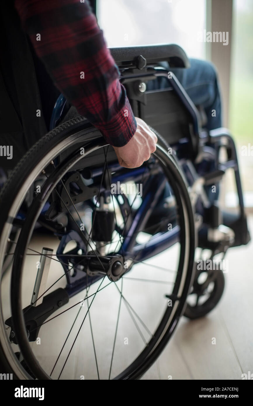 Close Up Of Man Sitting In Wheelchair At Home By Window Stock Photo