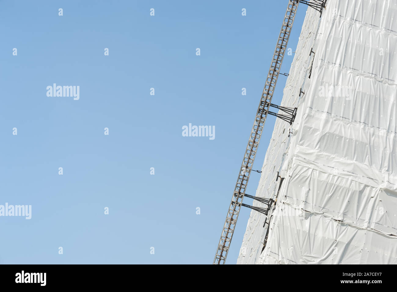 scaffolding and protective cladding on the exterior of a tower block ...