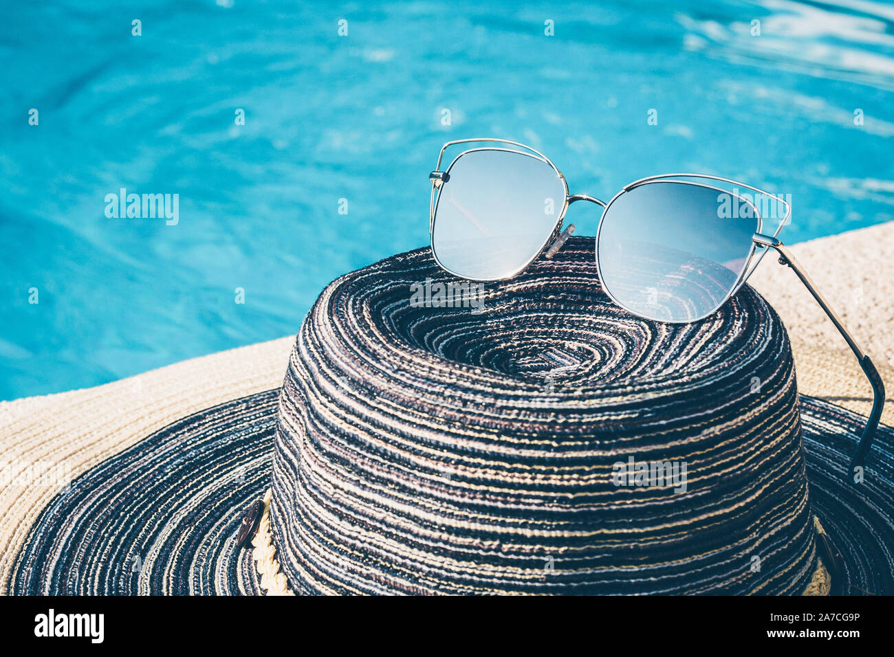 Women's hat and sunglasses near the pool on vacation Stock Photo - Alamy