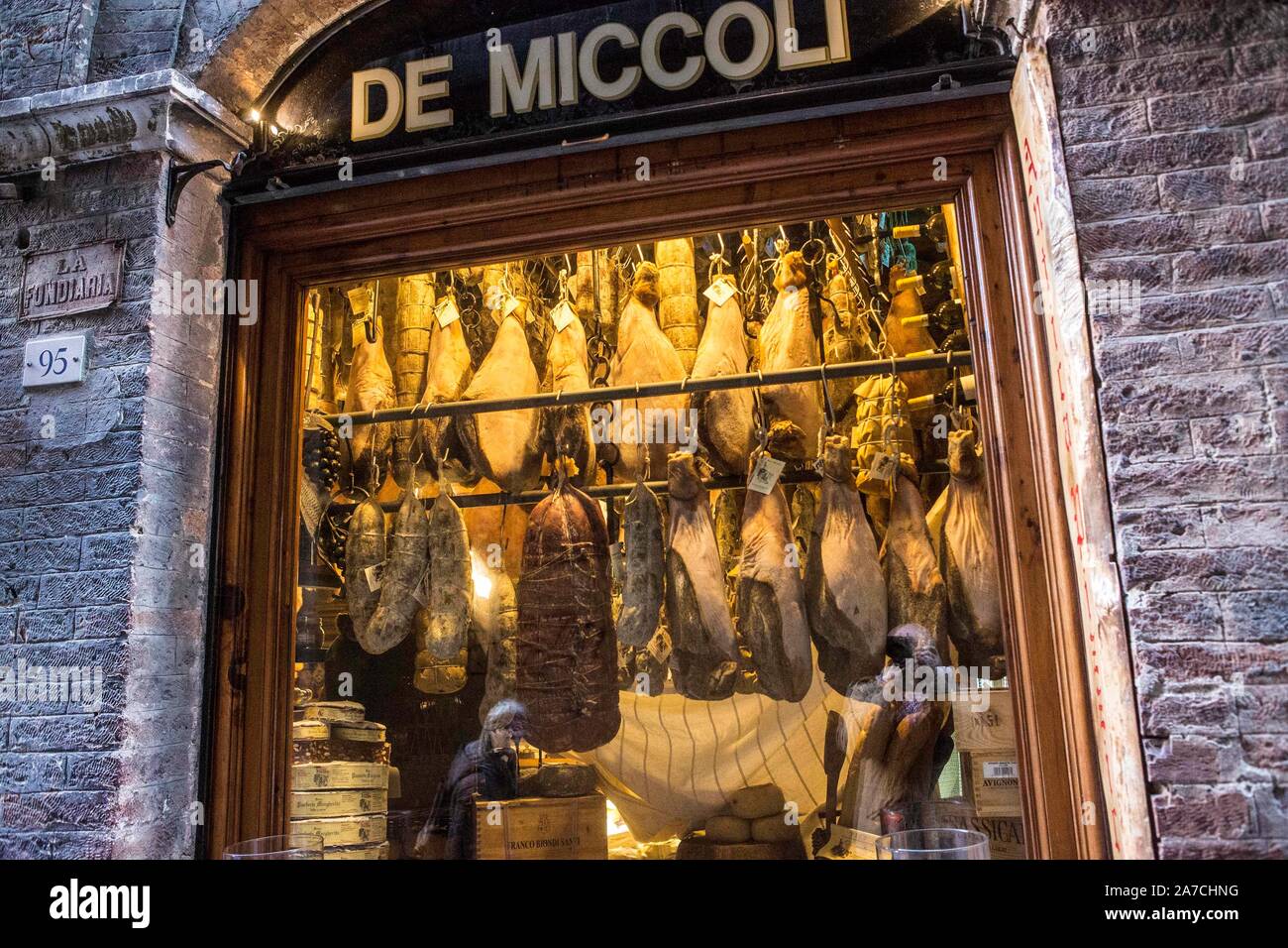 Feinkost in Siena: Pizzicheria de Miccoli verkauft Schinken, Wildschwein, Käse und andere Spezialitäten aus der Region. Die Schinkenkeulen hängen an d Stock Photo