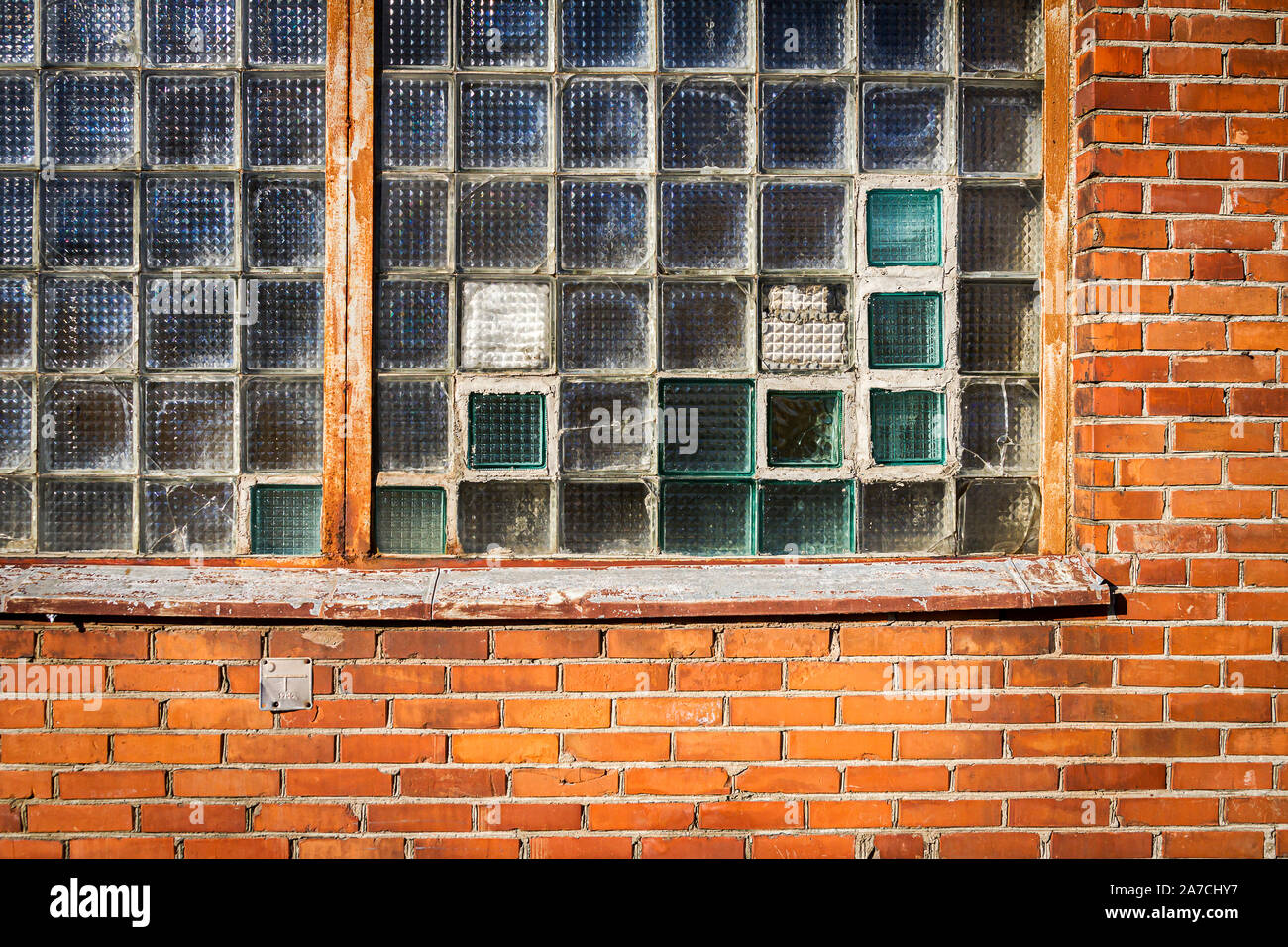 Red brick wall with glass block window. Architecture detail Stock Photo