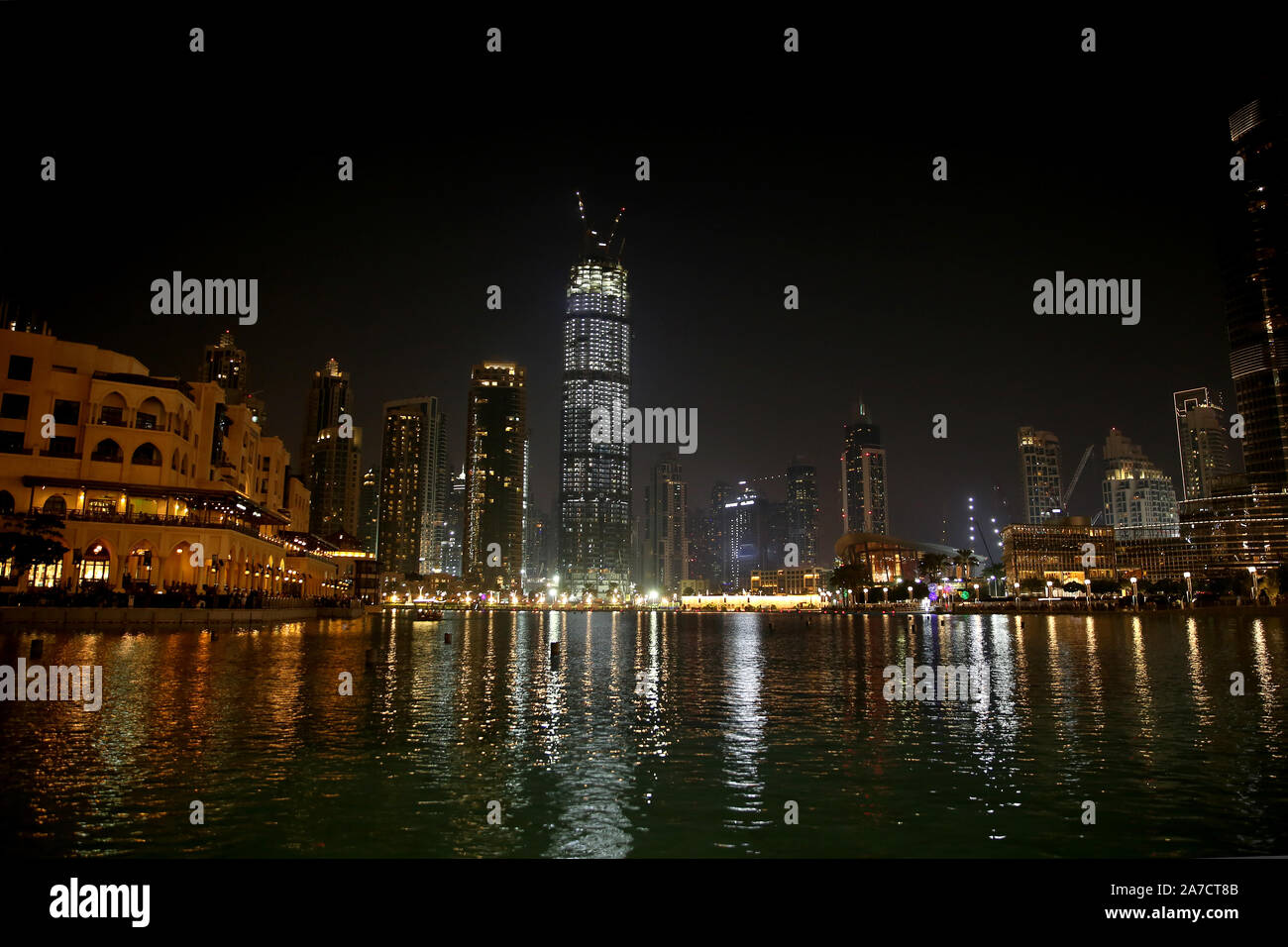 Downtown in the city at night with all the skyscrappers illluminated and reflecting in the lake, Dubai, United Arab Emirates. Stock Photo