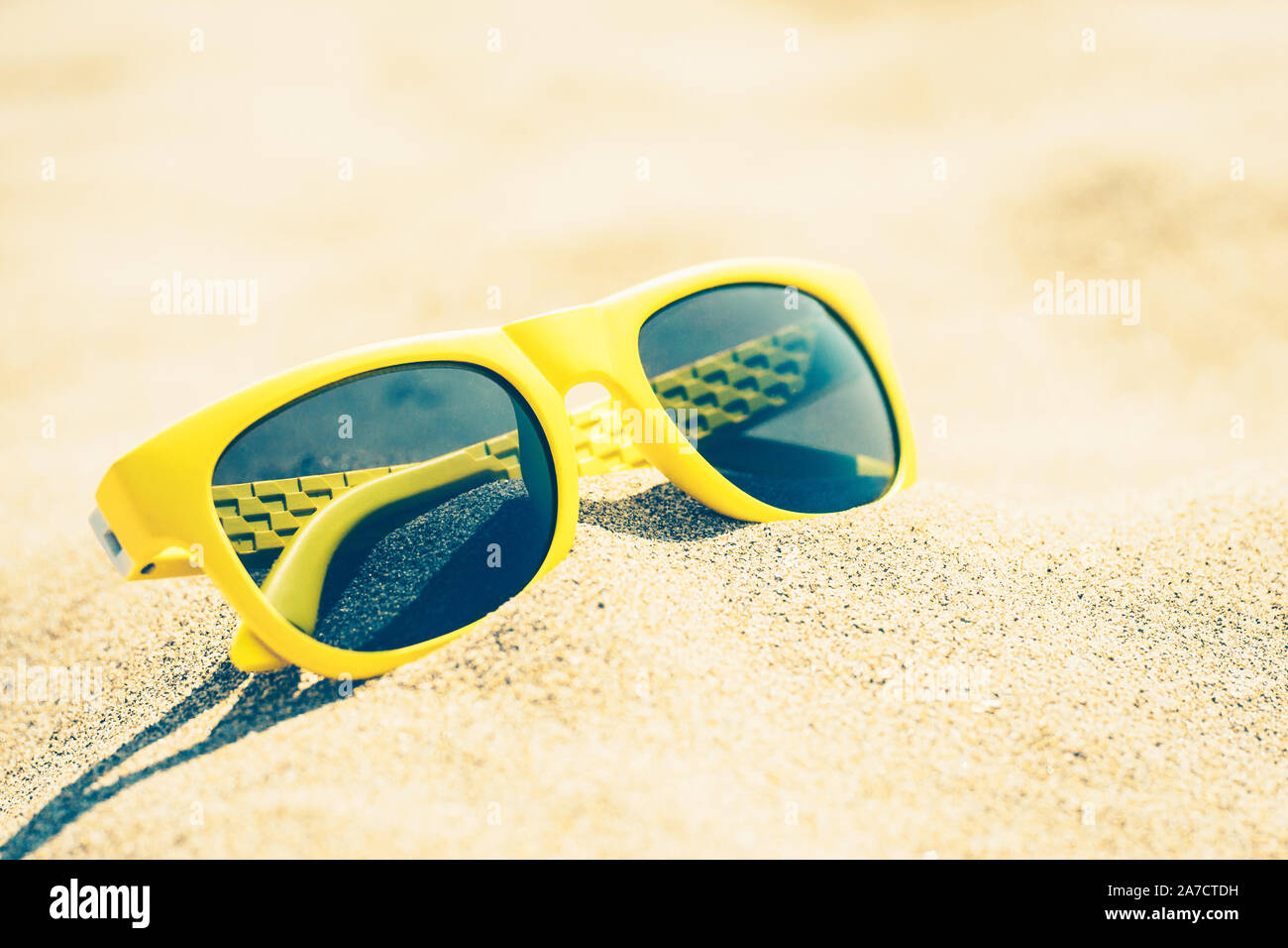 Vintage style - sunny yellow glasses on a sandy beach Stock Photo - Alamy