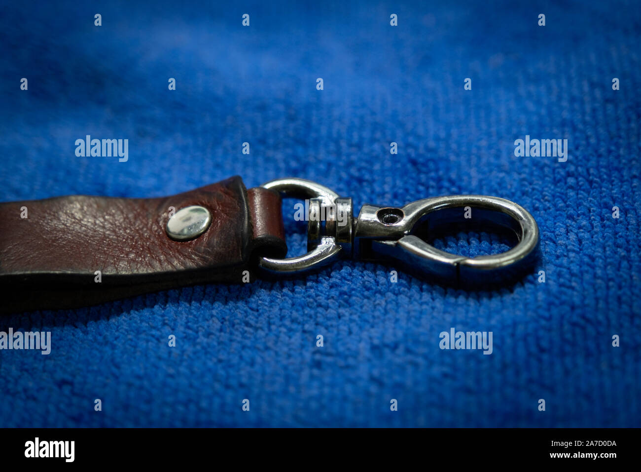Select focus Leather key chain with box on blue fabric background Stock Photo