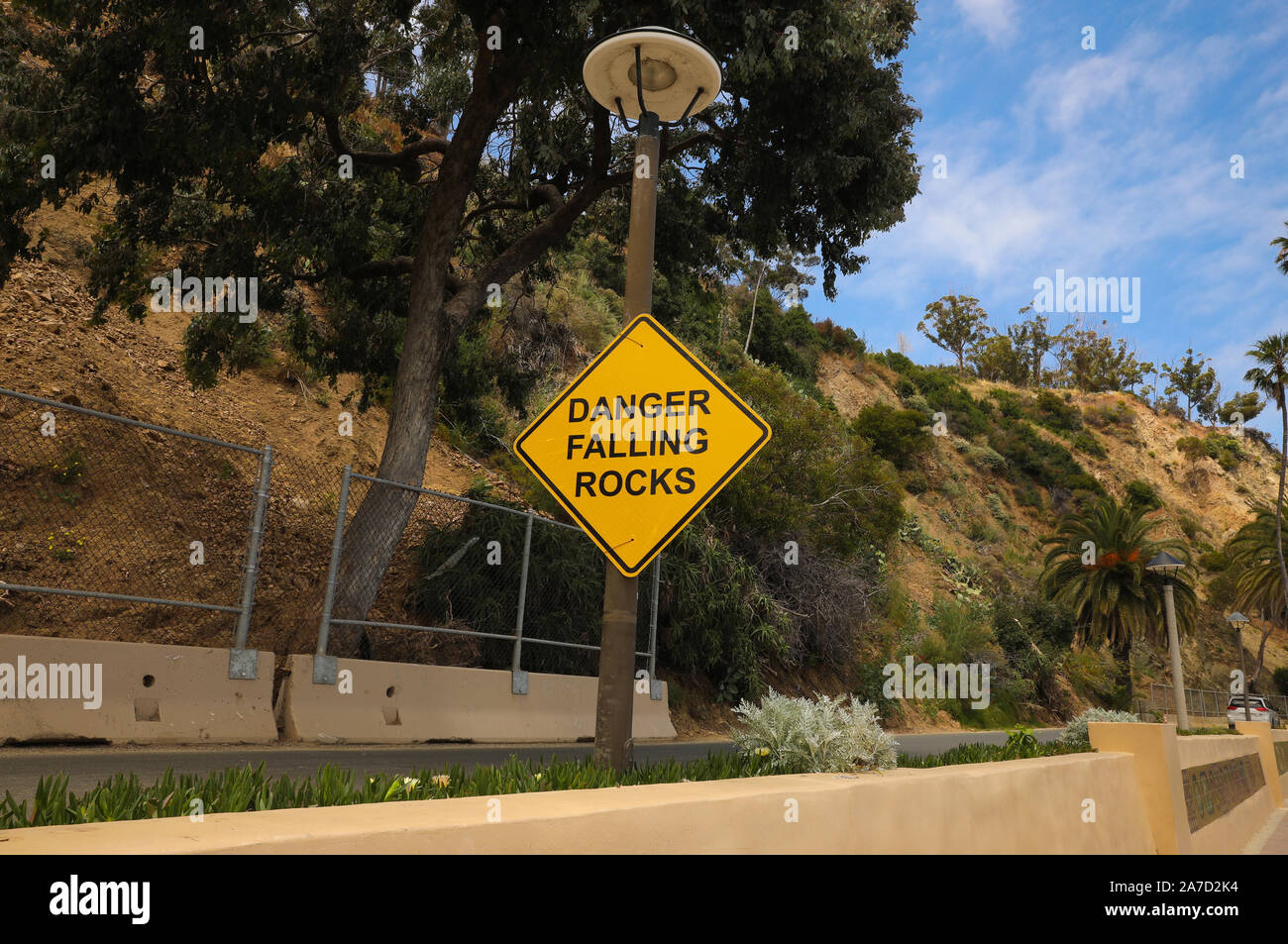 falling rocks Warning sign on a curvy road Stock Photo - Alamy