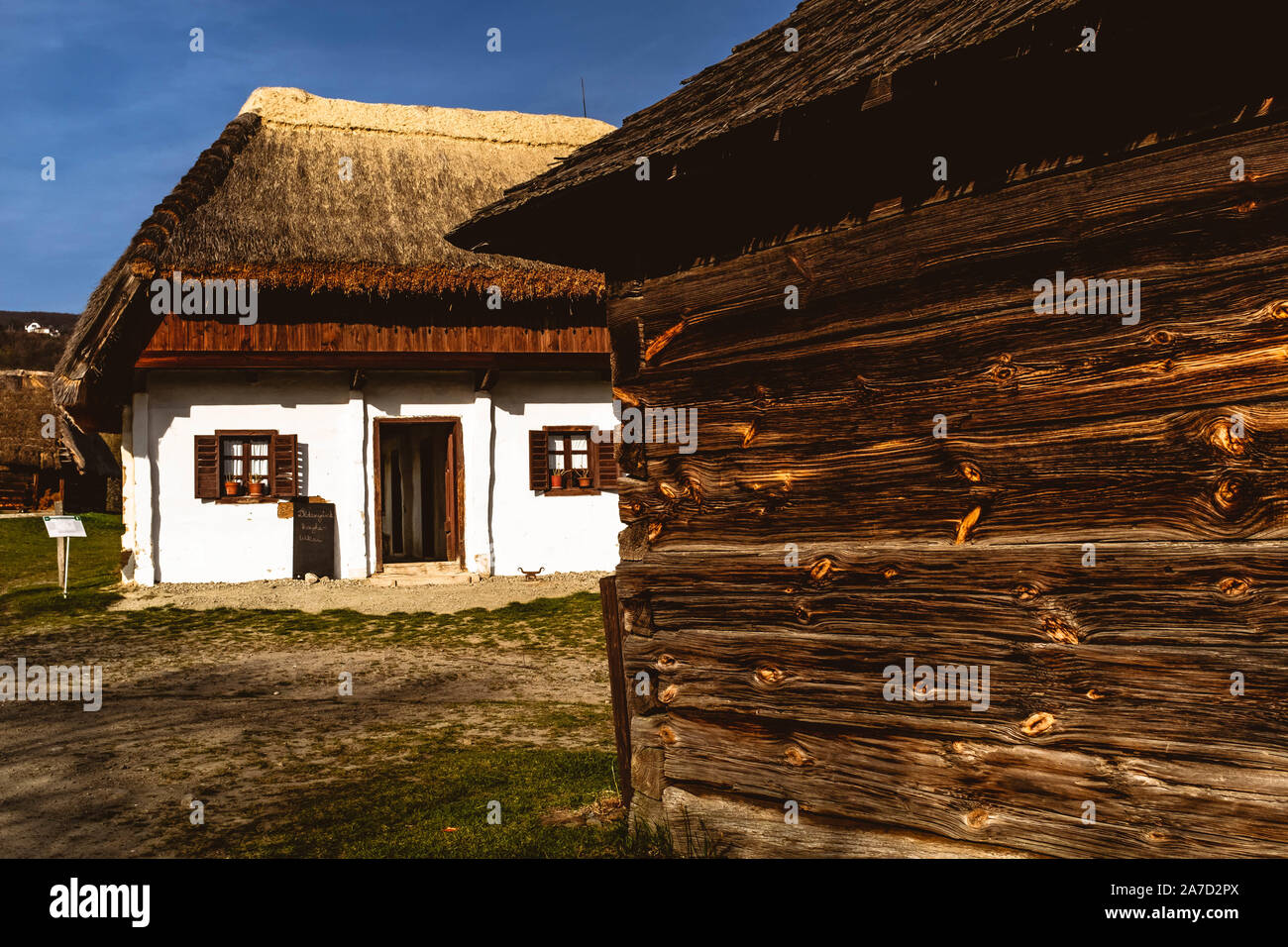 Traditional wooden and clay whitewashed Hungarian houses in Szentendre Skanzen Village Museum on a sunny spring day. Stock Photo