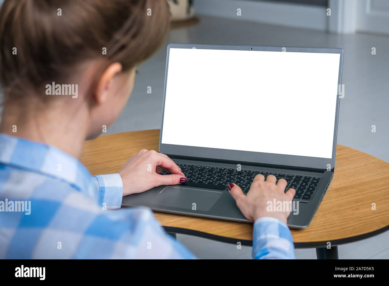 Woman freelancer typing on laptop computer keyboard with white blank screen Stock Photo