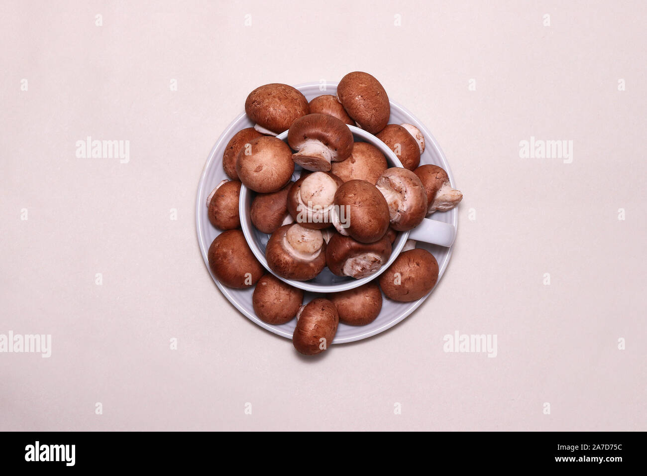 A small cup and saucer filled to overflowing with chestnut mushrooms