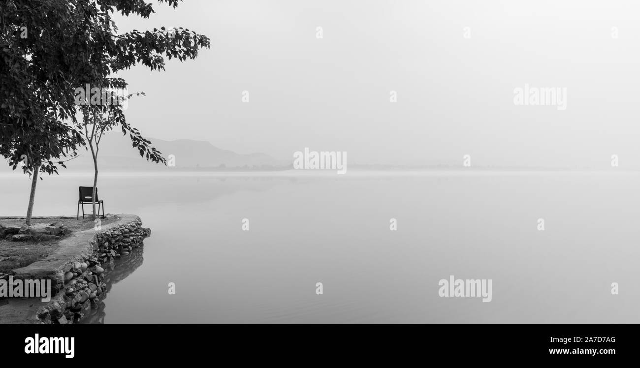 Black and white foggy morning and empty chair at Lake, Tarbela Dam Ghazi Stock Photo