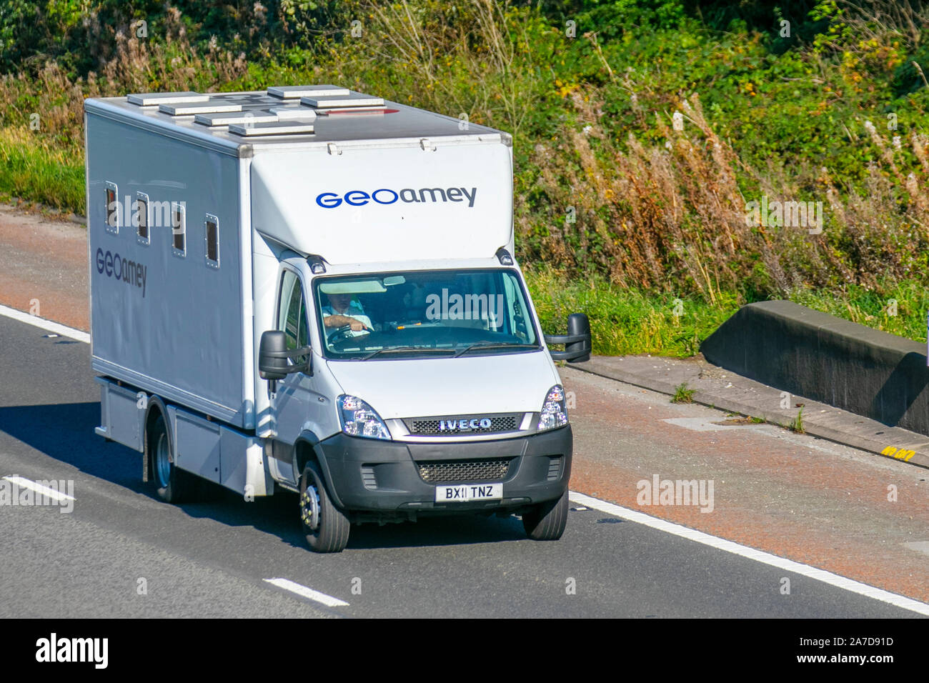 GeoAmey white Iveco Van; UK Vehicular traffic, transport, modern vehicles, commercial vans, south-bound on the 3 lane M6 motorway highway. Stock Photo