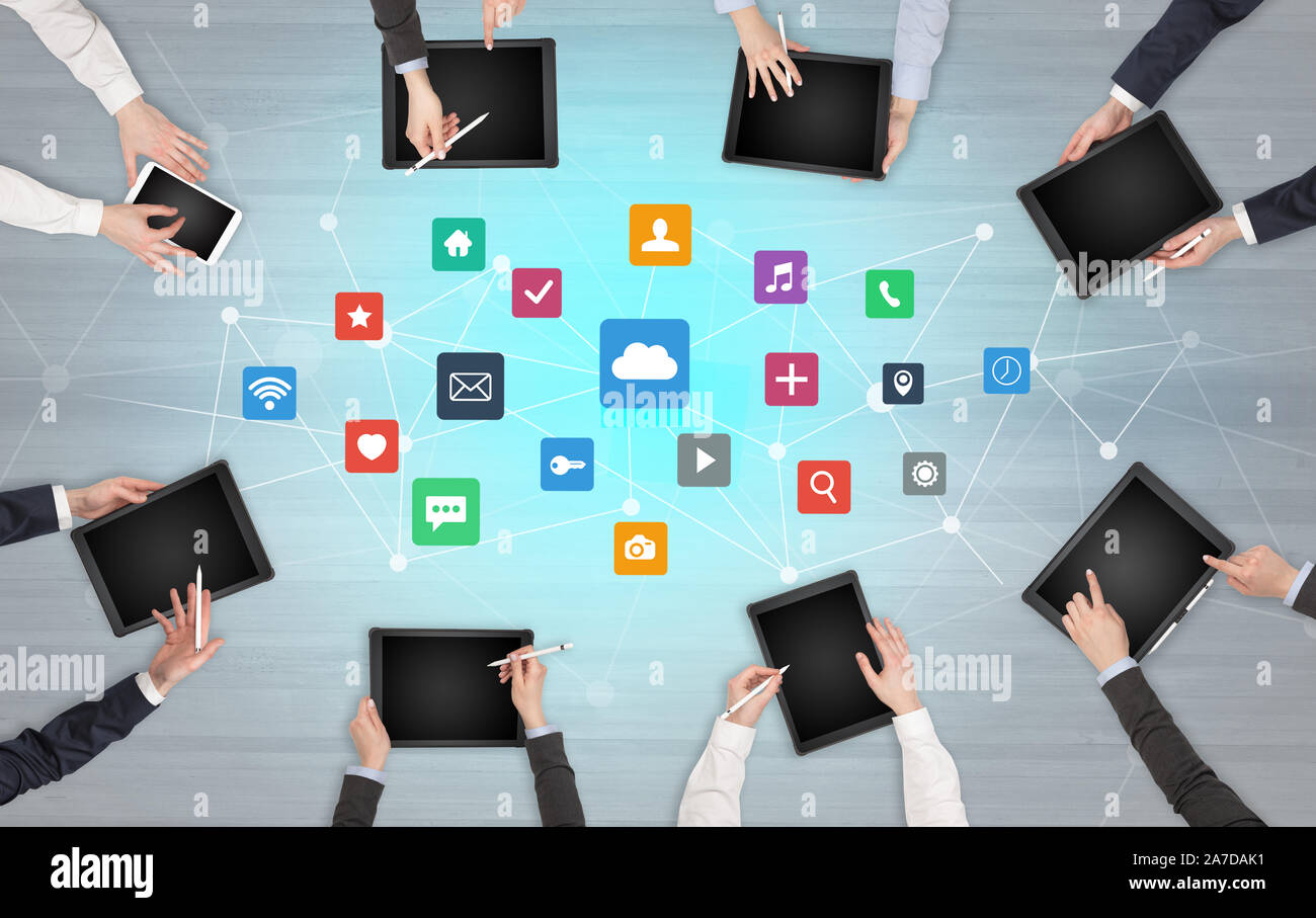 Group of people with devices in hands working in team on tablets ...