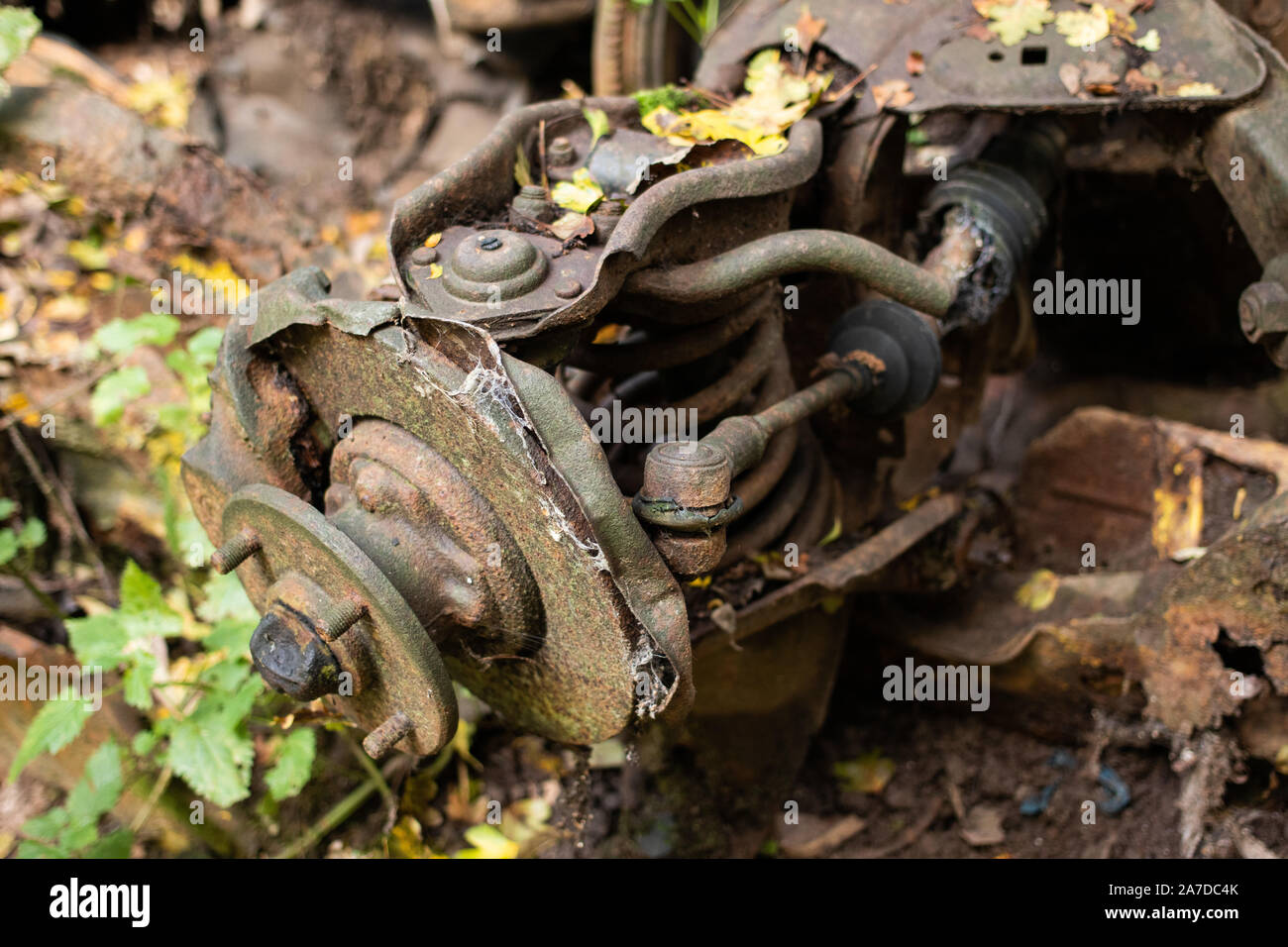Canal debris lying on the towpath of the Coventry canal near Nuneaton, Warwickshire. Part of a car suspension at the side of the canal, rusting. Stock Photo