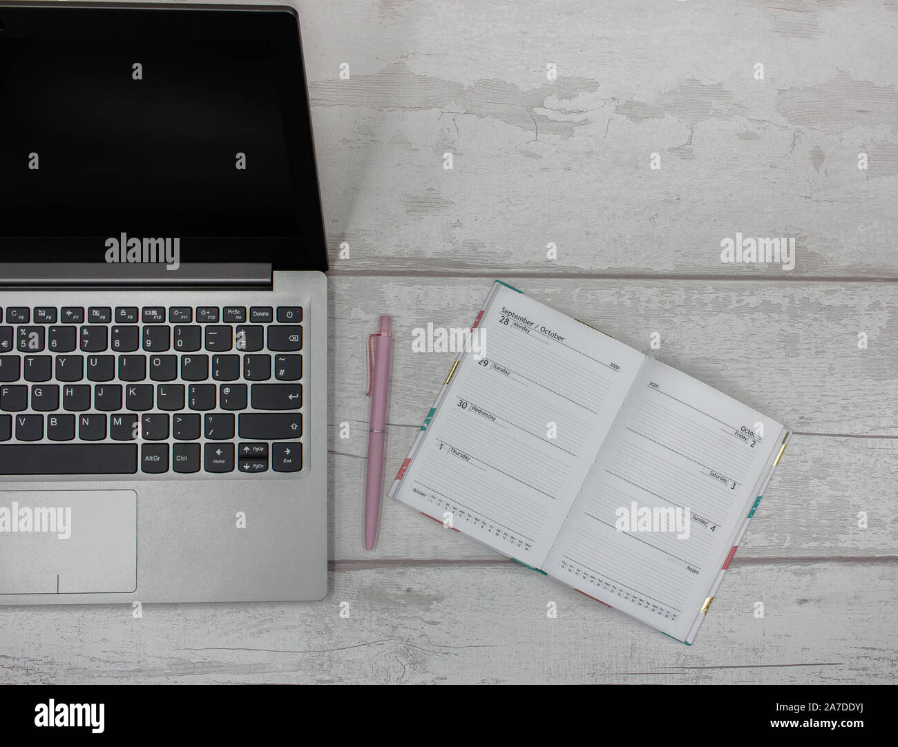 Top View of Laptop with Organizer Diary and Pink Pen on a Clean White Wooden Table Stock Photo