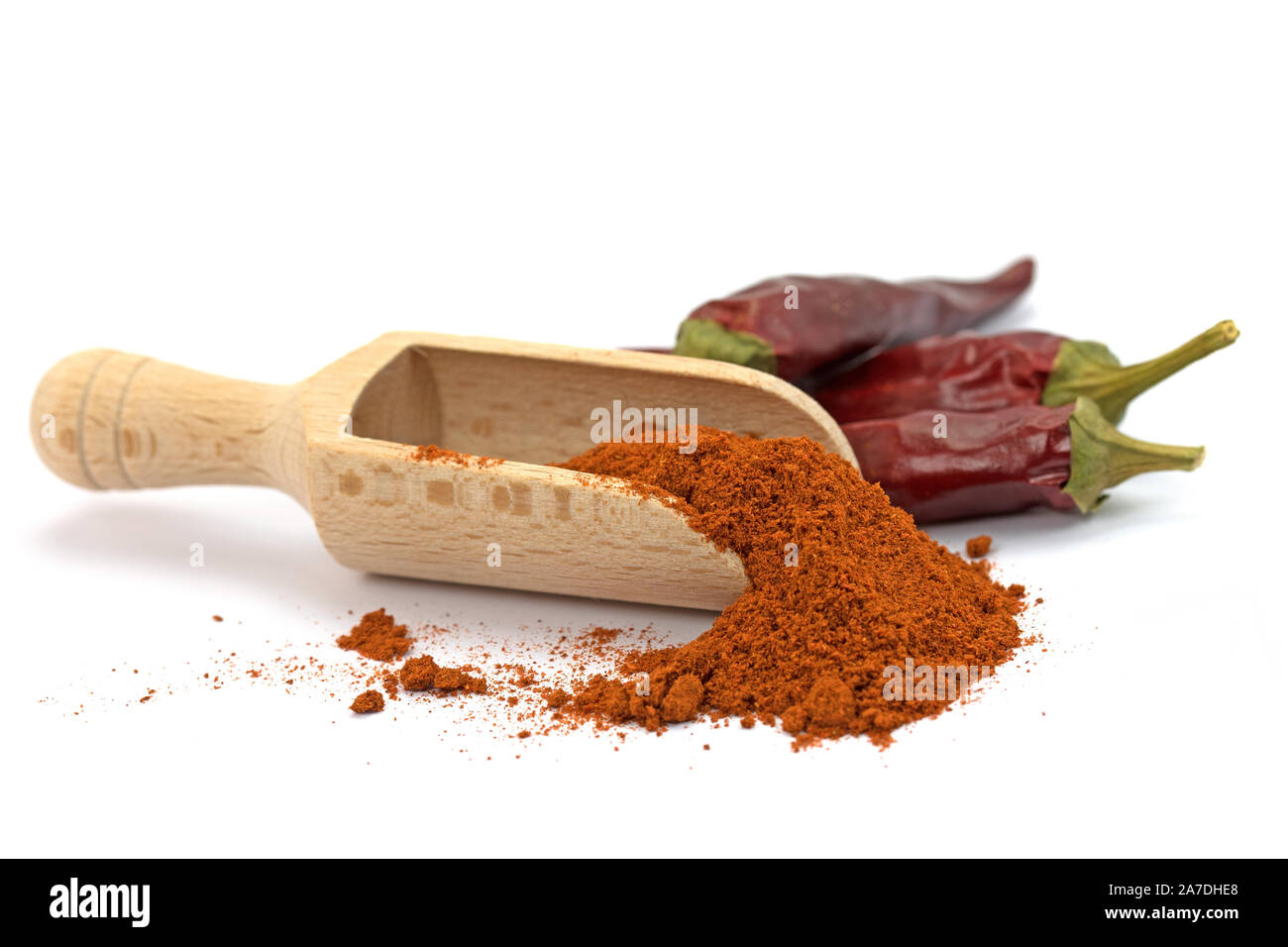 Paprika powder on a spice scoop in front of white background Stock