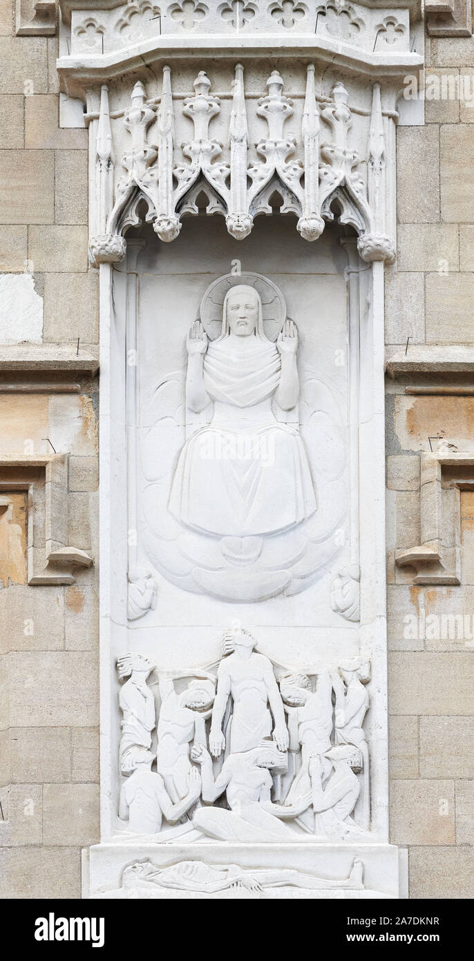 On an outside wall of All Souls college, university of Oxford, England, a stone carving of Jesus Christ in glory and the souls of dead people. Stock Photo