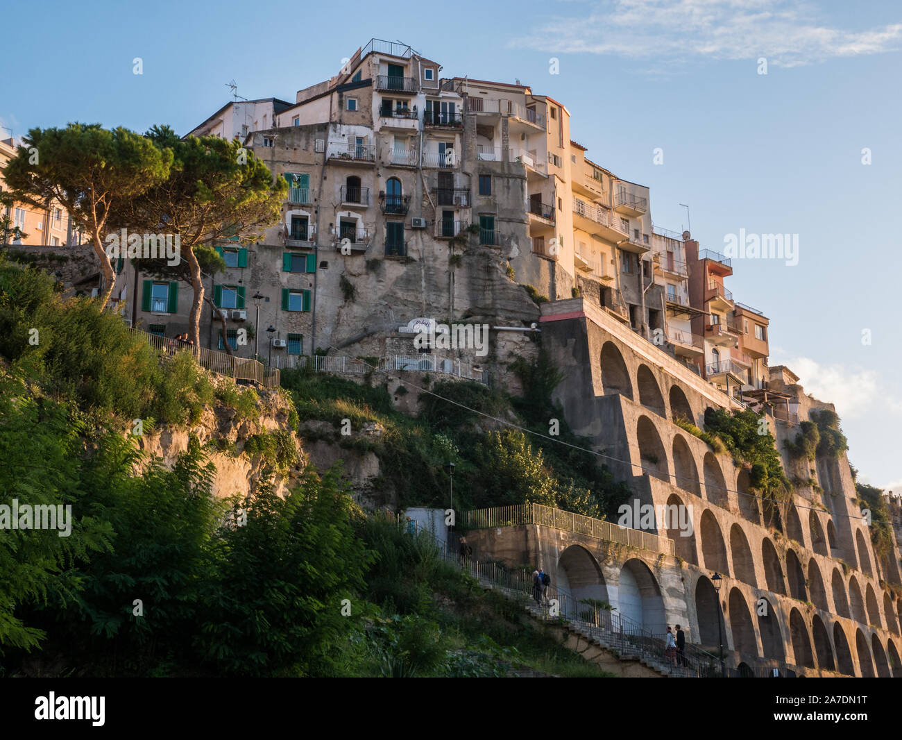 City center of Tropea, Calabria, Italy, old town, historic architecture of big buildings at scliffs with arches and arcades in sunset light from below Stock Photo