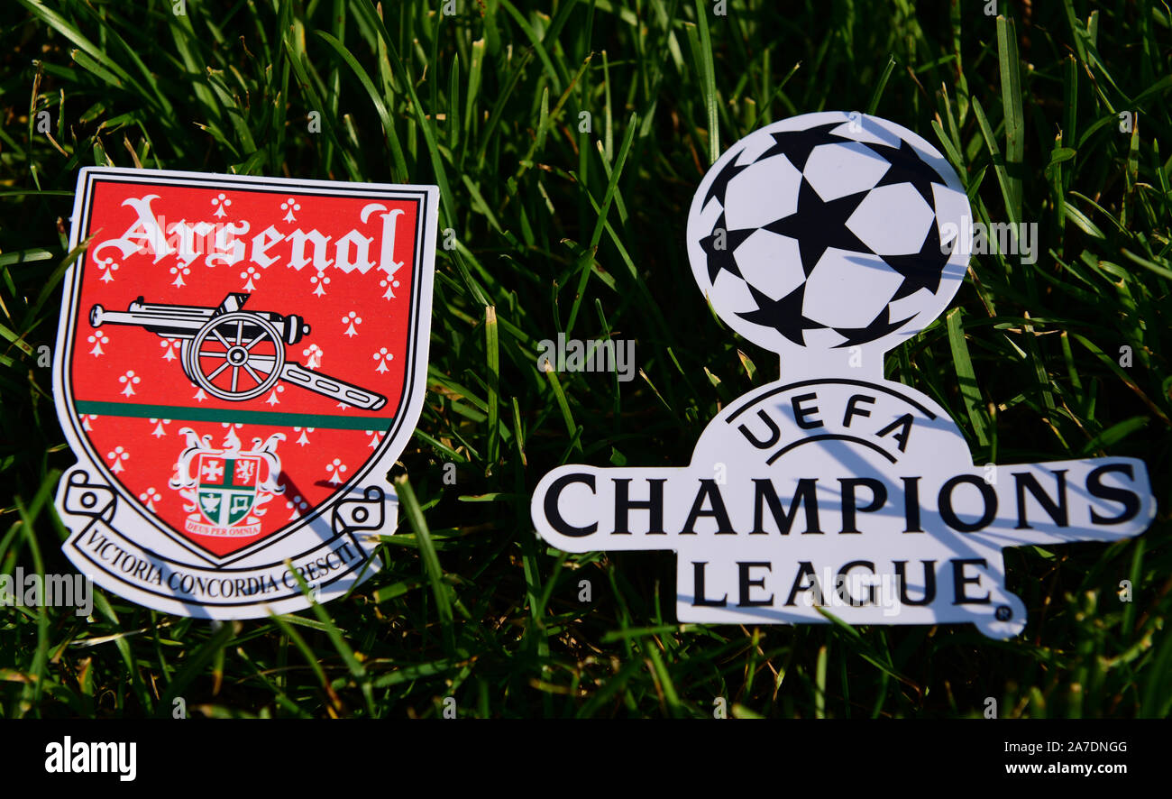 September 6, 2019 Istanbul, Turkey. The emblem of the English football club Arsenal London next to the logo of the Champions League on the green grass Stock Photo