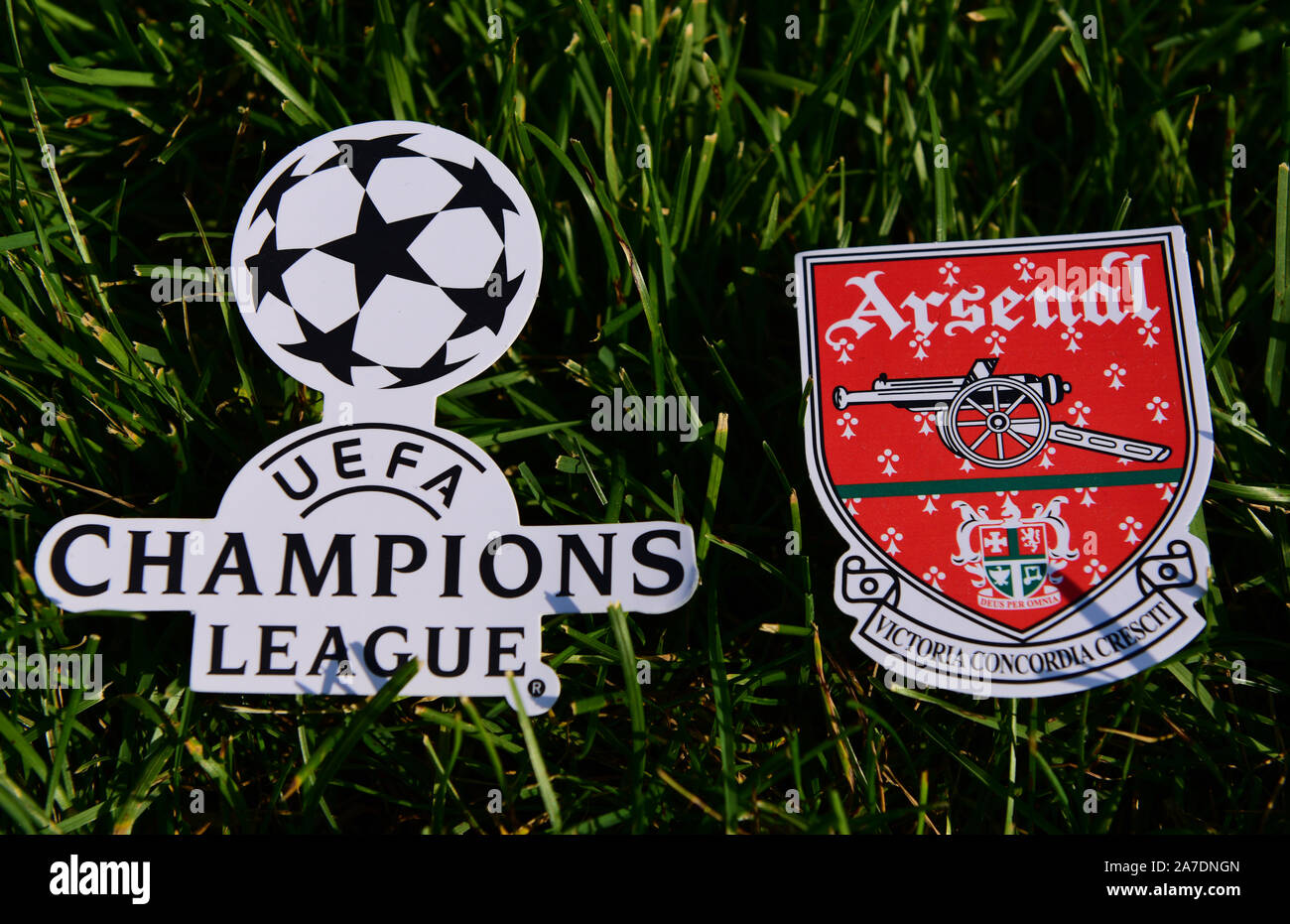 September 6, 2019 Istanbul, Turkey. The emblem of the English football club Arsenal London next to the logo of the Champions League on the green grass Stock Photo
