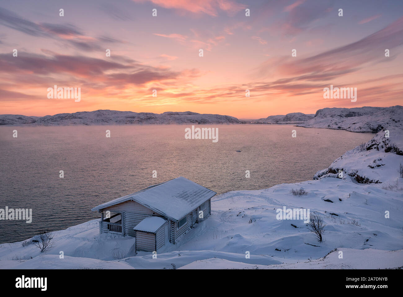 A wooden house, Barents sea at sunrise in Teriberka, Murmansk Region, Kola Peninsula. Russia. Stock Photo