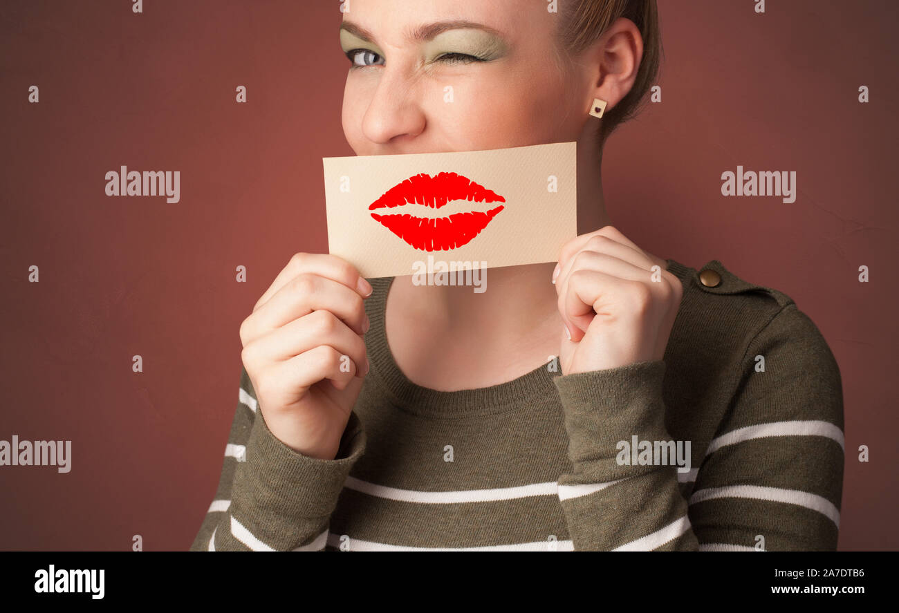 Person smiling with a card on the front of his mouth with a red lips on