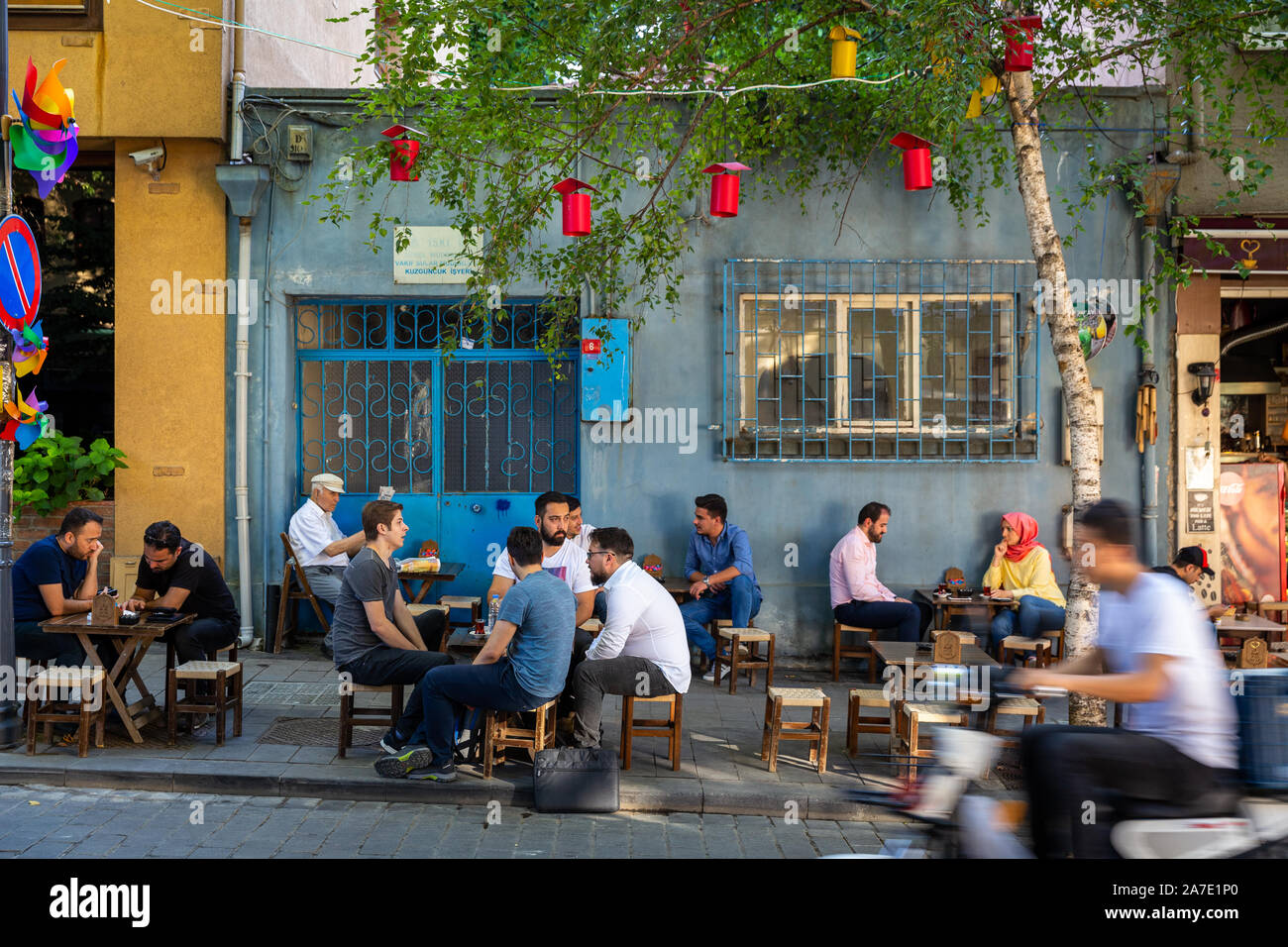 Turkish people are spending time at street cafes in Kuzguncuk.Kuzguncuk is a neighborhood in the Uskudar district on the Asian side of the Bosphorus. Stock Photo