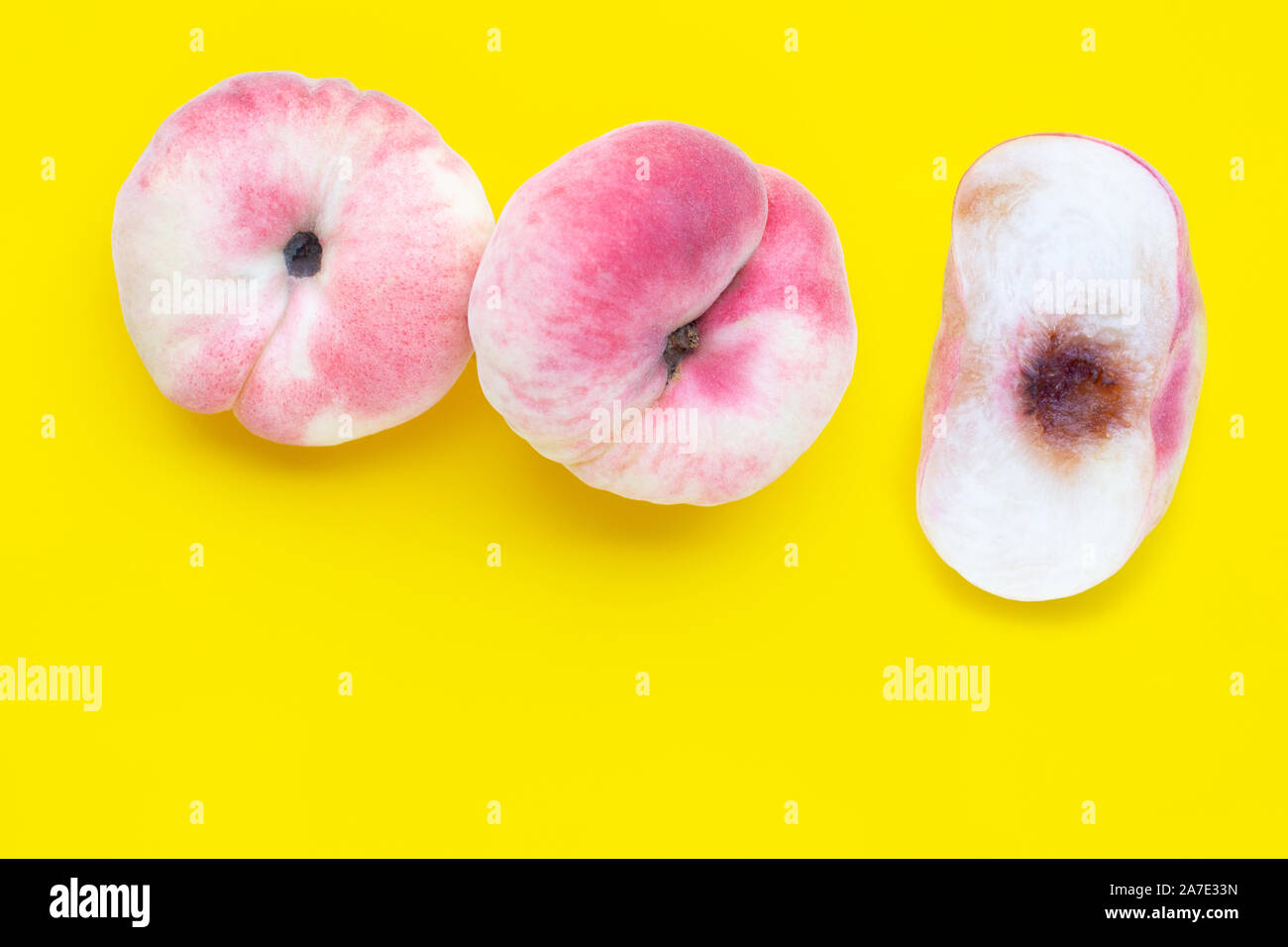 Chinese flat peaches on yellow background. Copy space Stock Photo