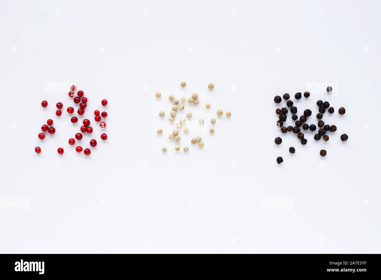 Red, white and black peppercorns on white background Stock Photo Alamy