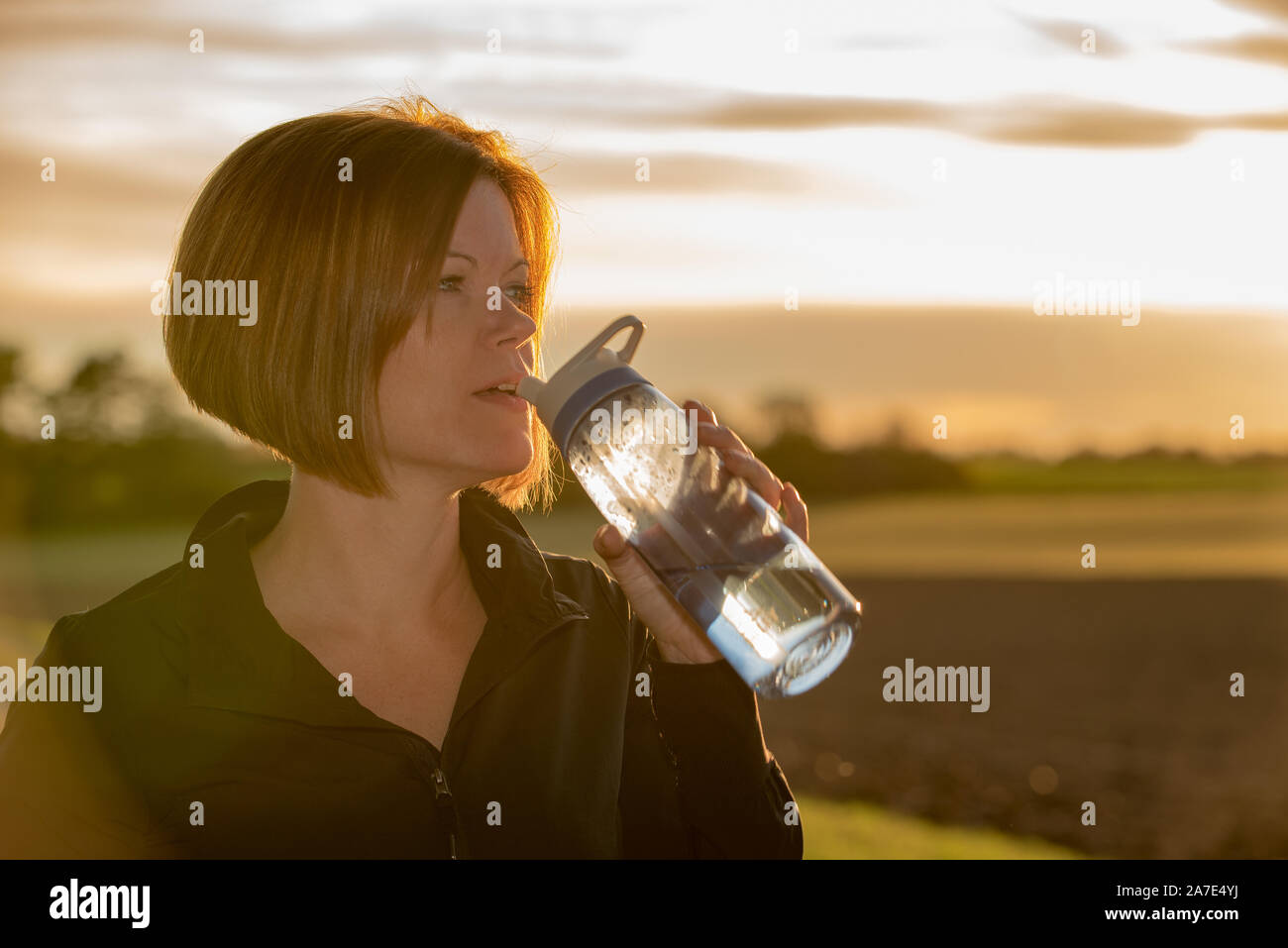 Young woman drinking water during sport outside Stock Photo