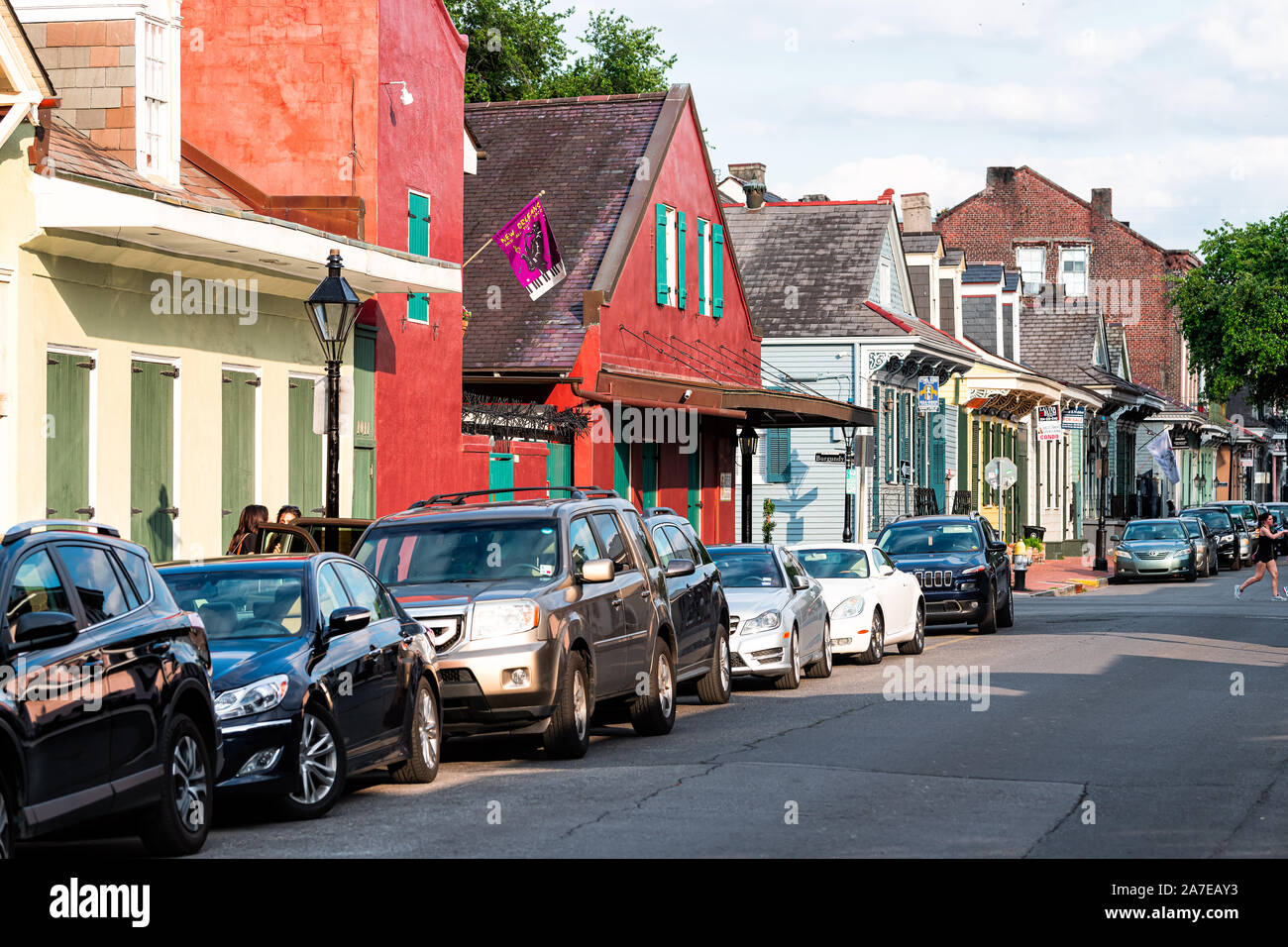 New Orleans, USA - April 23, 2018: Old town Orleans street in Louisiana famous town with row of red colorful buildings homes and parked cars Stock Photo