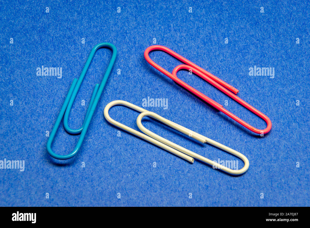 Paper clip on the blue background Stock Photo - Alamy