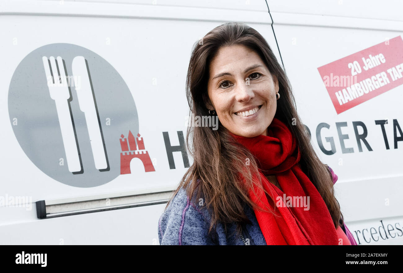 Hamburg, Germany. 28th Oct, 2019. Julia Bauer, board member of the  Hamburger Tafel, stands in front of a transporter with which food is  collected and delivered. The Tafel celebrates its 25th anniversary