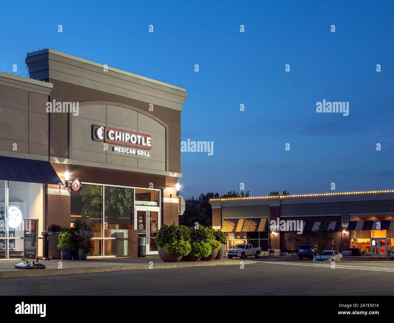 New Hartford, New York - Aug 18, 2019: Vertical 4:3 Night View of Chipotle Maxican Grill Restaurant, Chipotle is an American Fast Food Brand Specializ Stock Photo