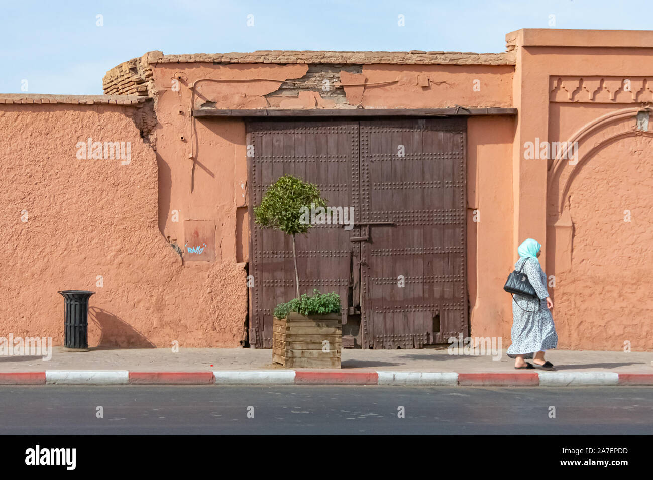 Arab woman and wooden door in the city of Marrakech. Morocco October 2019 Stock Photo
