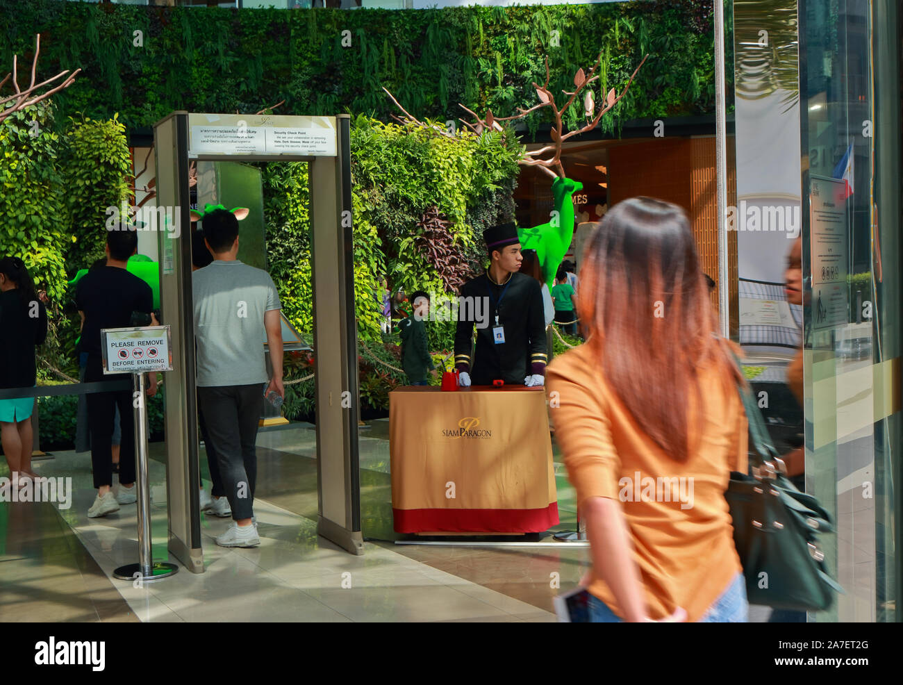 Bangkok, Thailand - October 31 2019 : Closeup back of a young man walking through metal detector at entrance of shopping mall, security concept Stock Photo