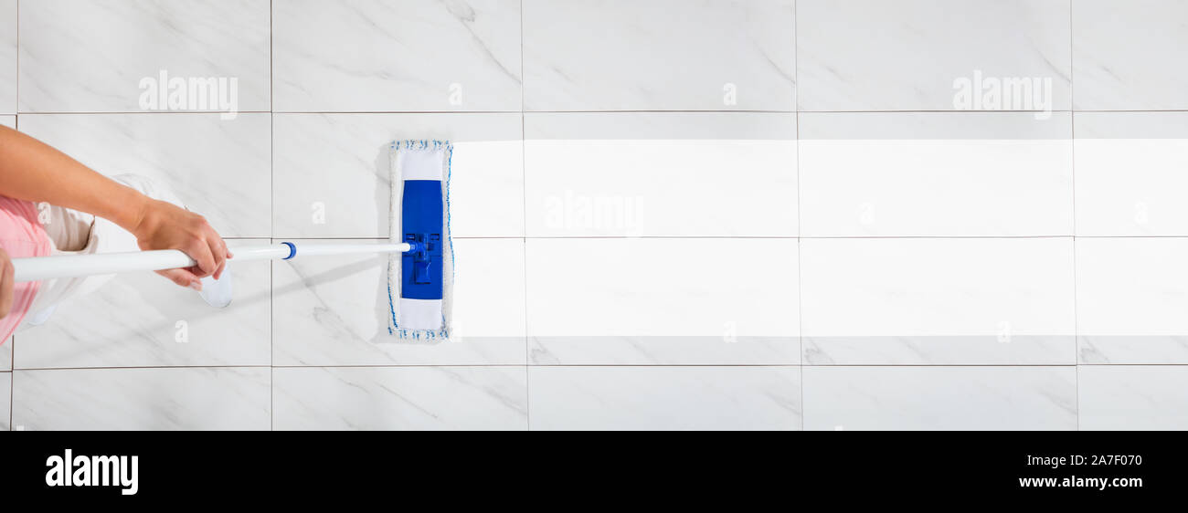 An Overhead View Of A Female Cleaning The White Floor With Wet Mop Stock Photo