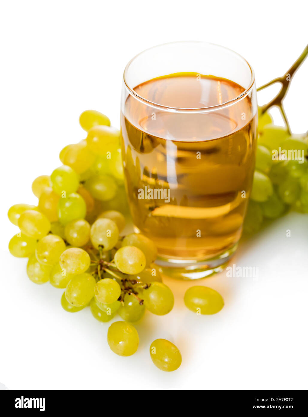 glass of grape juice with bunch of ripe green grapes on a white ...
