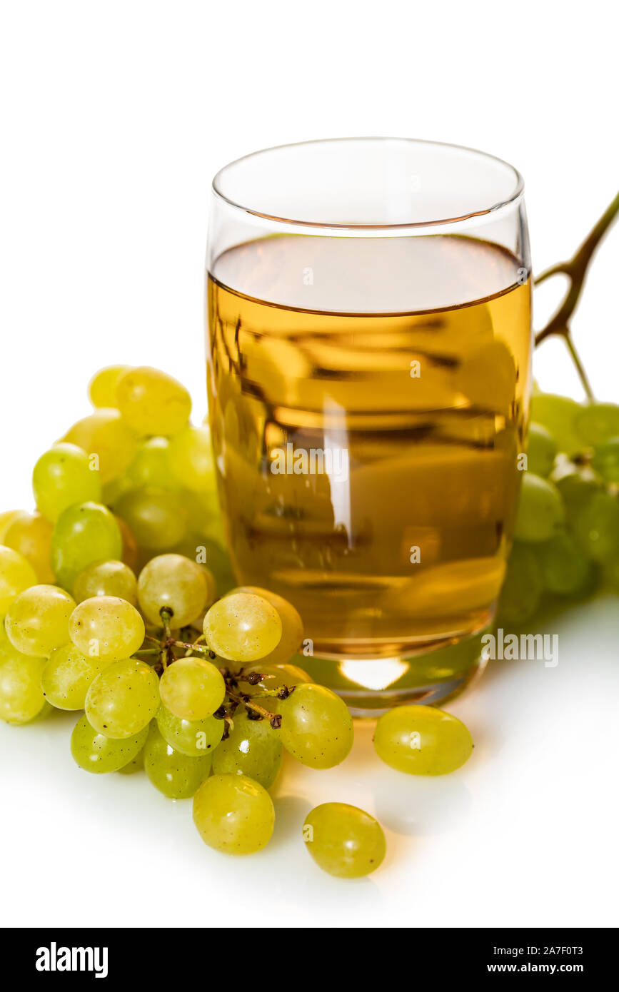 glass of grape juice with bunch of ripe green grapes on a white ...