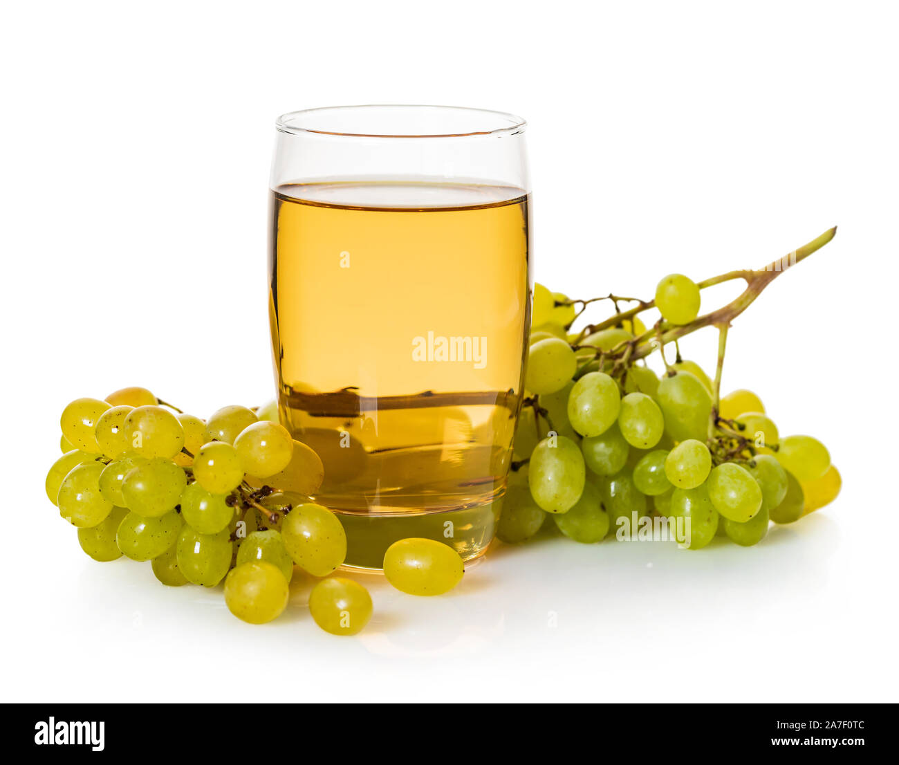 glass of grape juice with bunch of ripe green grapes on a white ...