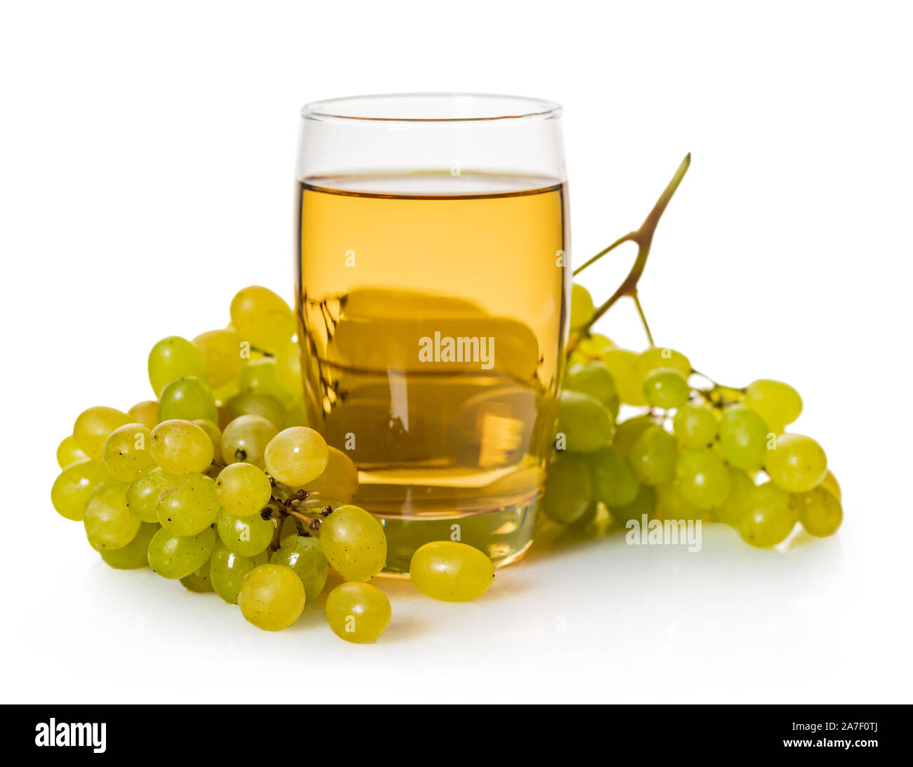 glass of grape juice with bunch of ripe green grapes on a white ...
