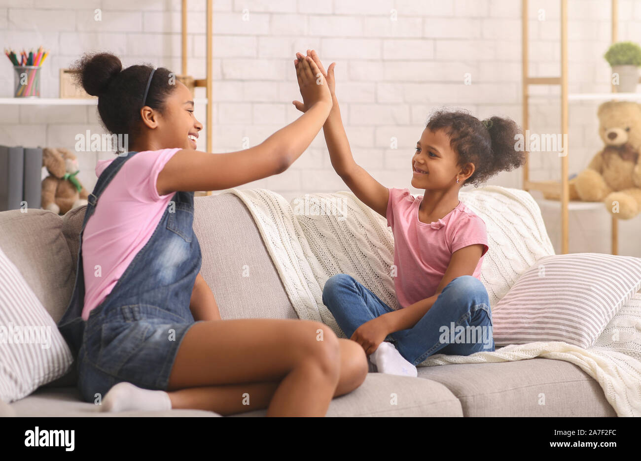 Happy african sisters giving high five at home Stock Photo Alamy