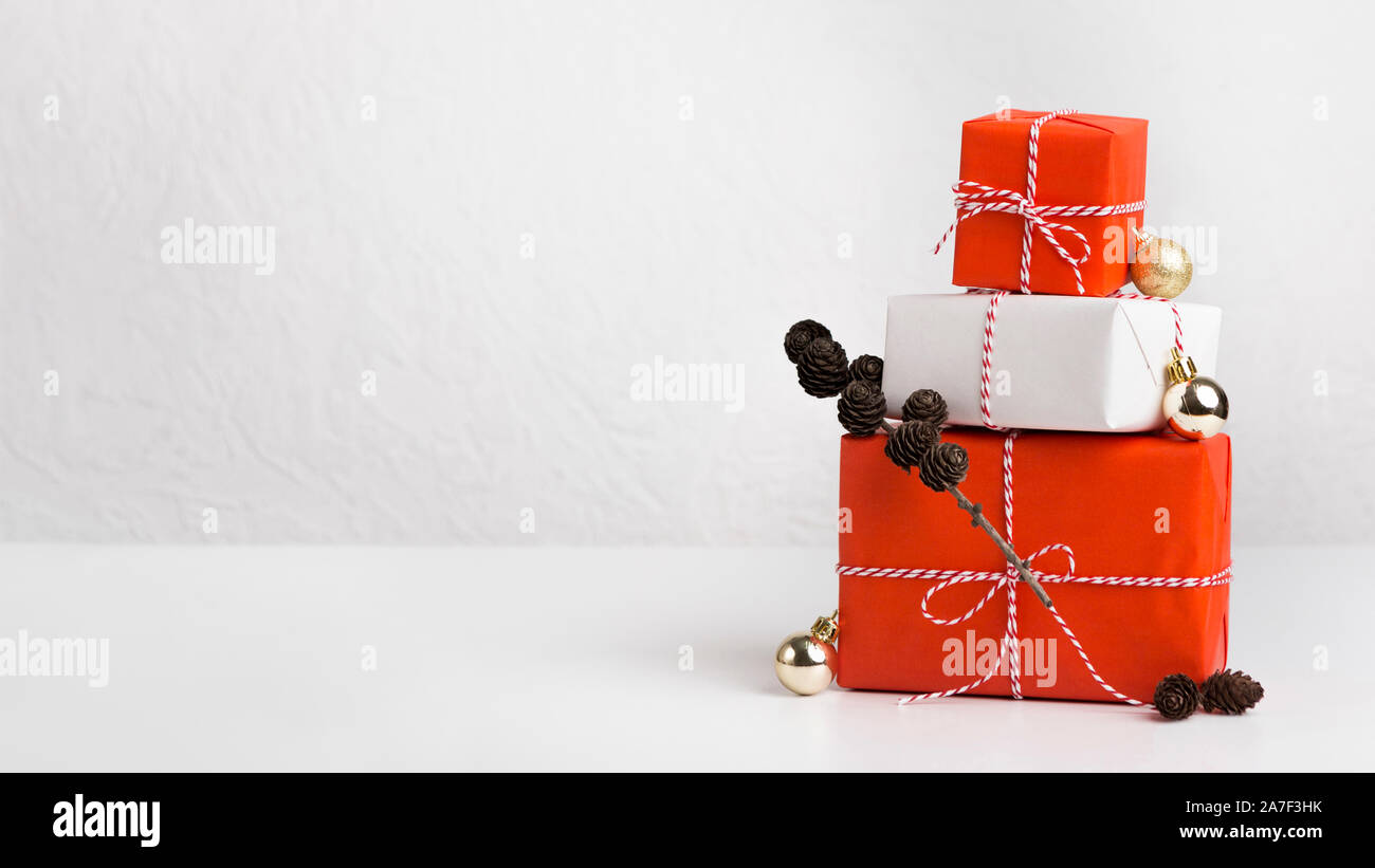 Gift boxes of red and white paper decorated by cones Stock Photo