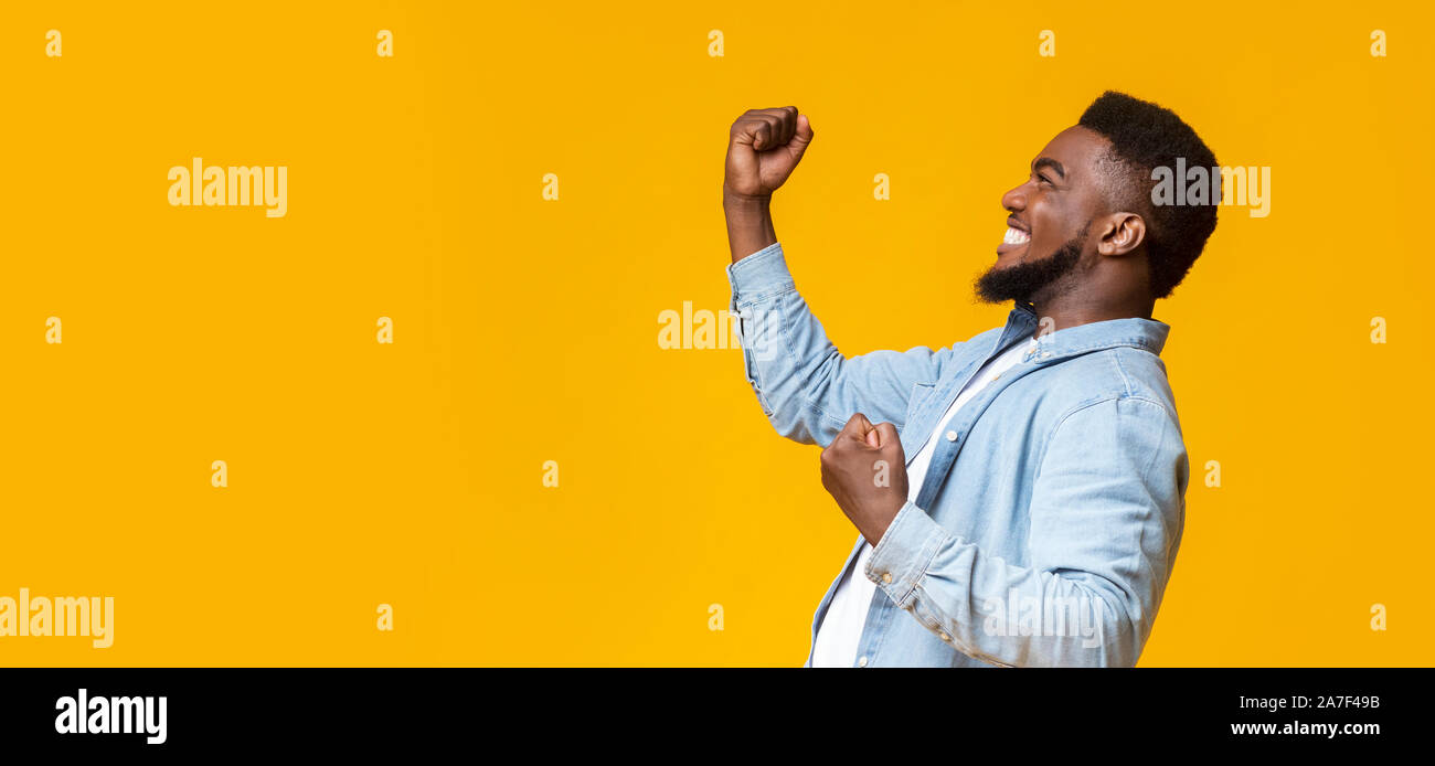 Happy black guy raising fists in the air, celebrating success Stock ...