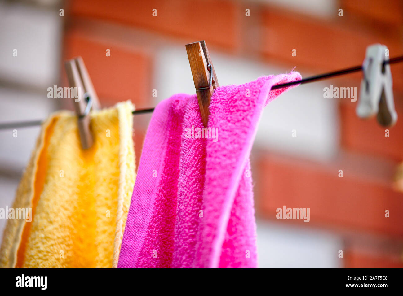 Two towels with clothespins hanging on clothesline outdoors. Close up. Stock Photo