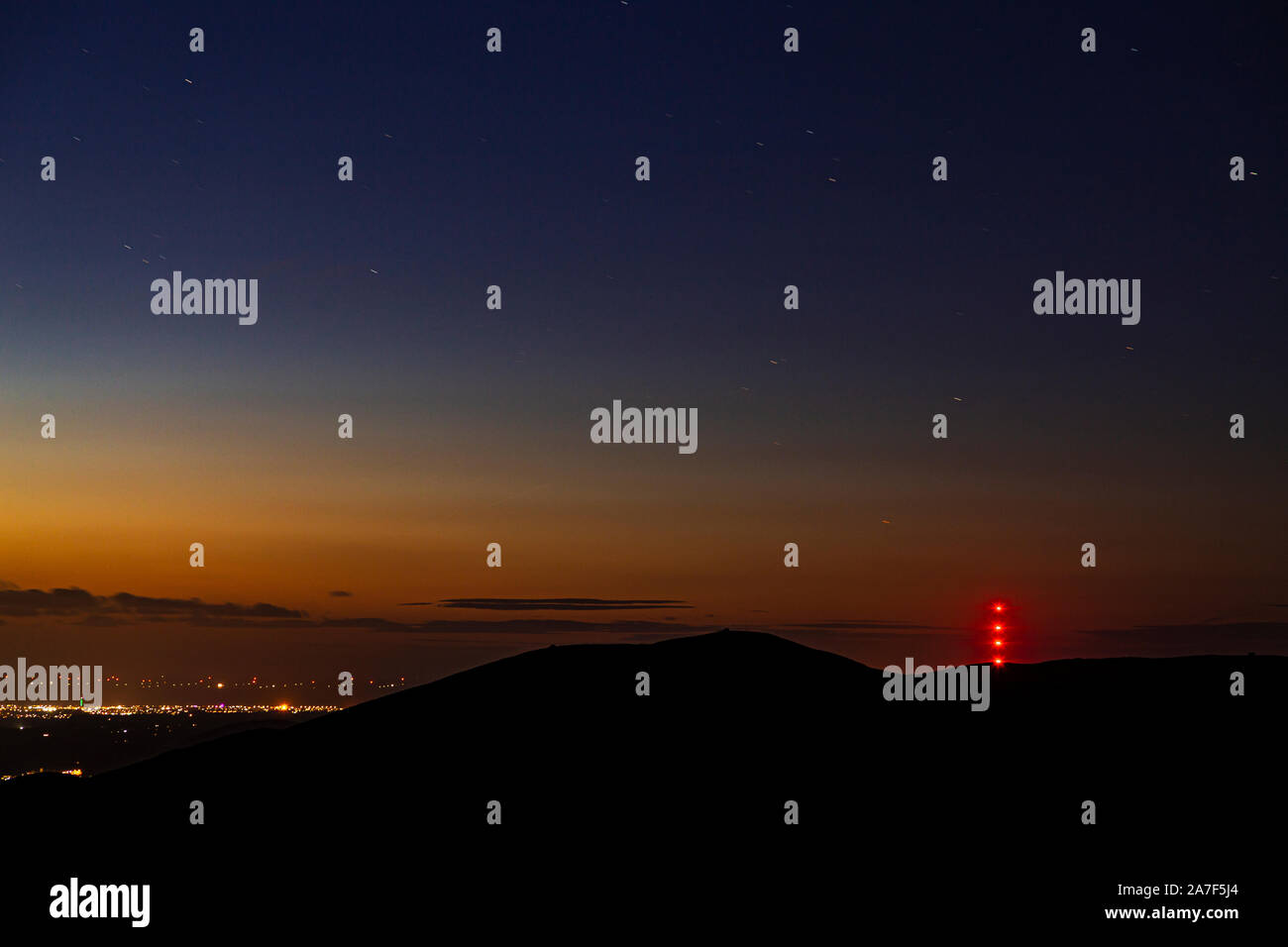 Clwydian range hills at night with stars and Moel y Parc transmitter mast Stock Photo